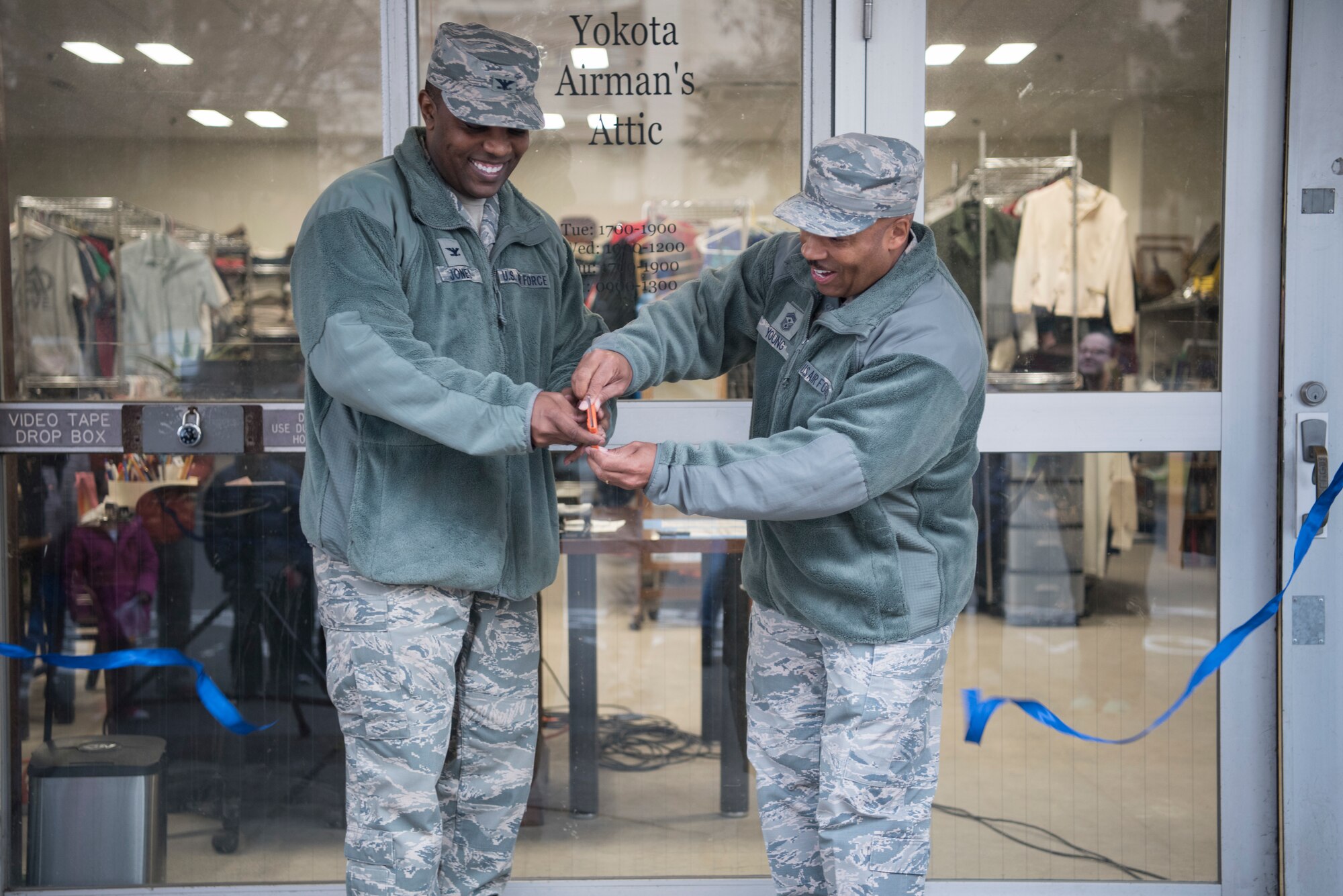 Col. Otis C. Jones, 374th Airlift Wing commander, and Chief Master Sgt. Elvin Young, 374th Airlift Wing command chief, cut the ribbon during the reopening of the Airman's Attic, Jan. 12, 2019, at Yokota Air Base, Japan.
