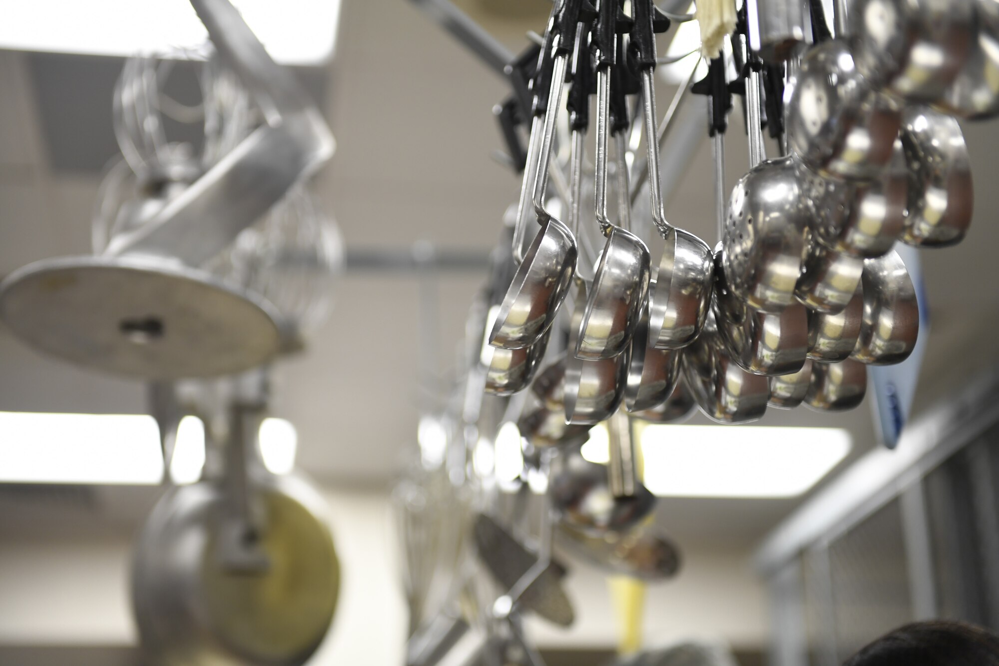 Kitchen utensils hang from a kitchen rack in the dining facility at the North Carolina Air National Guard Base, Charlotte Douglas International Airport, Jan. 12, 2019. Food services Airmen from the North Carolina Air National Guard train members from the Niagara Falls Air Reserve Station, New York, on full-service kitchen operations in preparation for the upcoming Air Force active duty and reserve Hennessy Award competition.