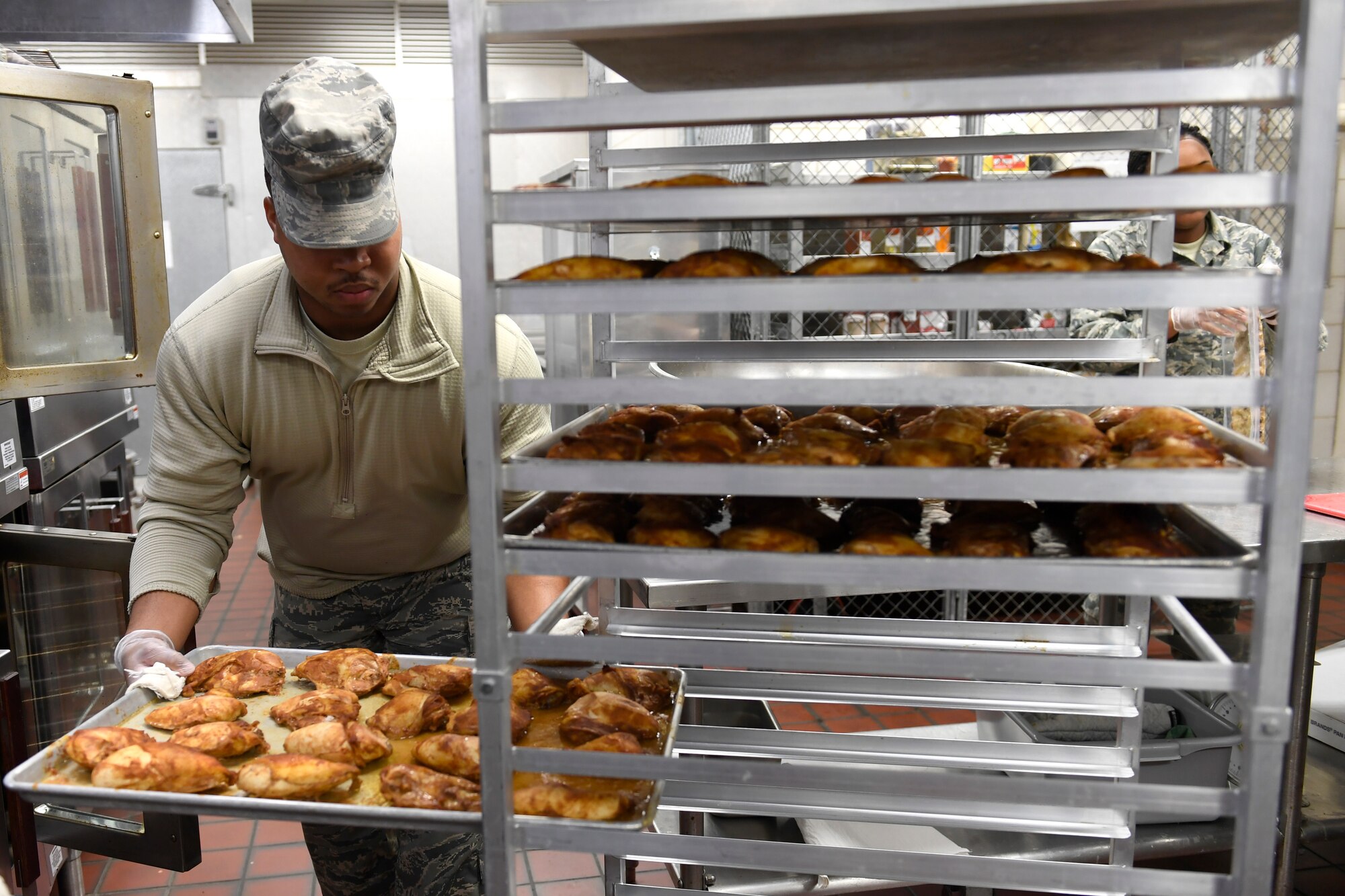 U.S. Air Force Senior Airman Deontre Barrett, 145th Force Support Squadron, places a pan of cooked chicken on a rack for lunch in the dining facility during drill weekend at the North Carolina Air National Guard Base, Charlotte Douglas International Airport, Jan. 12, 2019. Food services Airmen from the North Carolina Air National Guard train members from the Niagara Falls Air Reserve Station, New York, on full-service kitchen operations in preparation for the upcoming Air Force active duty and reserve Hennessy Award competition.