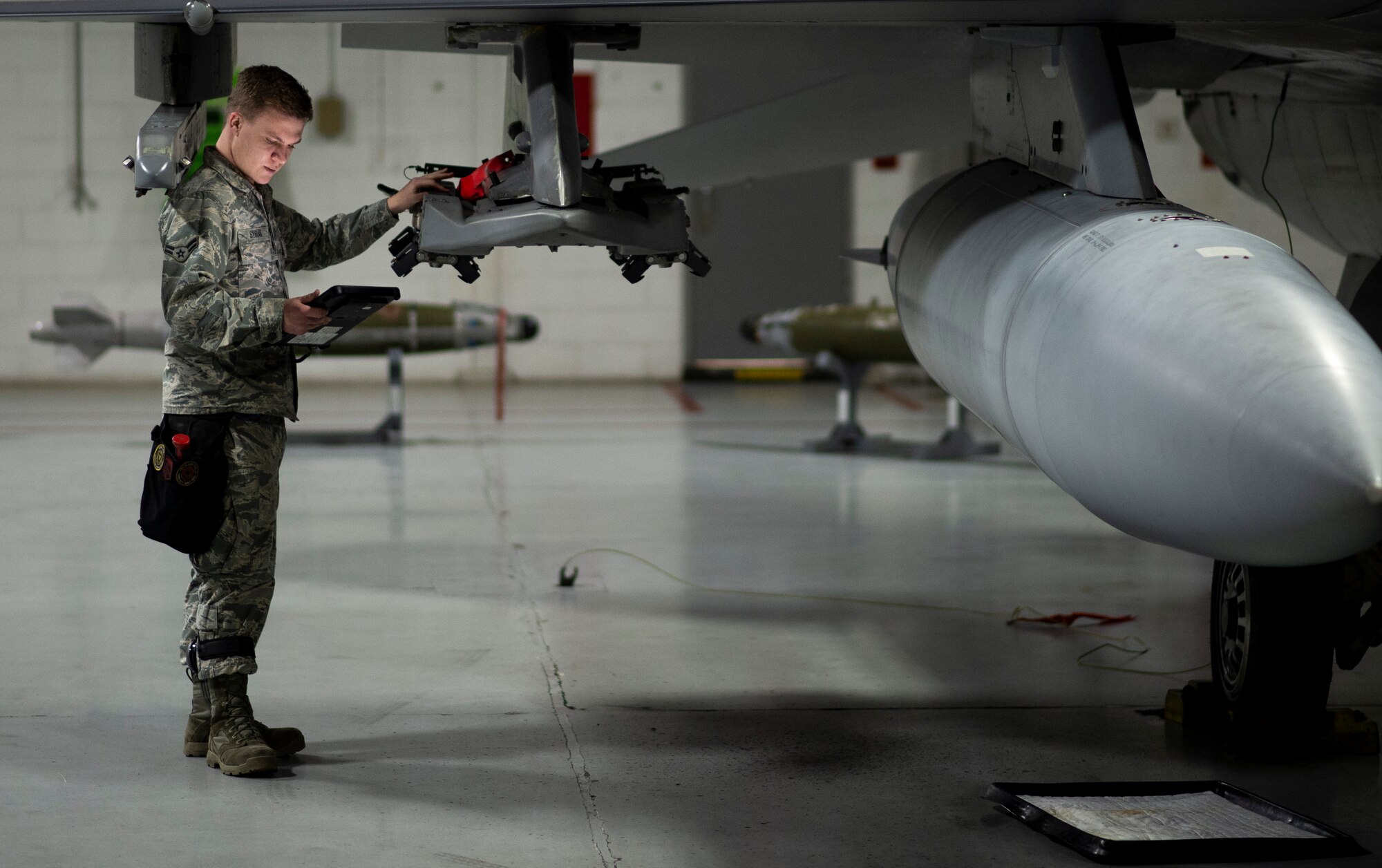 U.S. Air Force Airman 1st Class Gavin Sybiak, 20th Aircraft Maintenance Squadron, 79th Aircraft Maintenance Unit weapons load team member, inspects an F-16CM Fighting Falcon weapon rack at Shaw Air Force Base, S.C., Jan. 10, 2019.