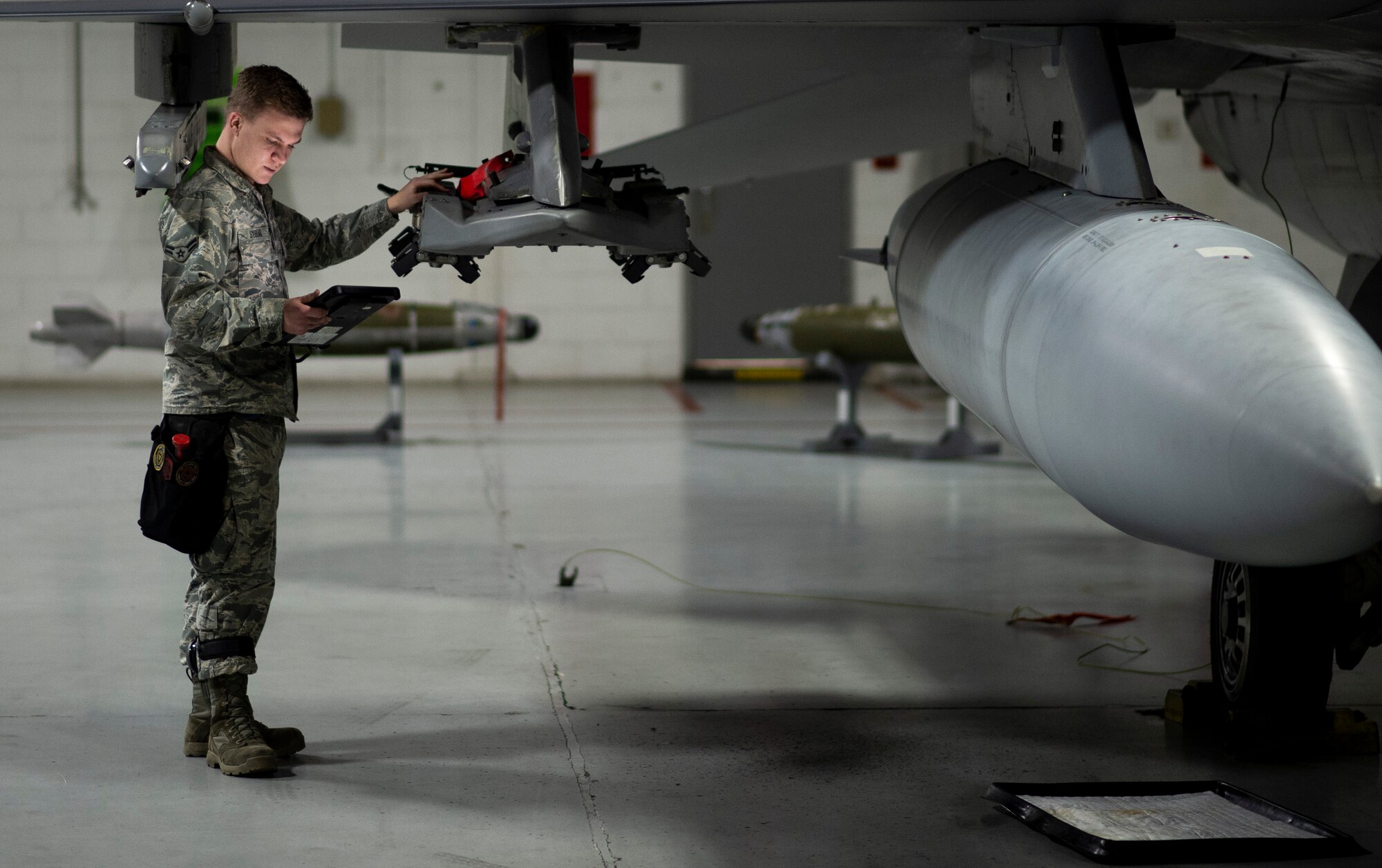 U.S. Air Force Airman 1st Class Gavin Sybiak, 20th Aircraft Maintenance Squadron, 79th Aircraft Maintenance Unit weapons load team member, inspects an F-16CM Fighting Falcon weapon rack at Shaw Air Force Base, S.C., Jan. 10, 2019.