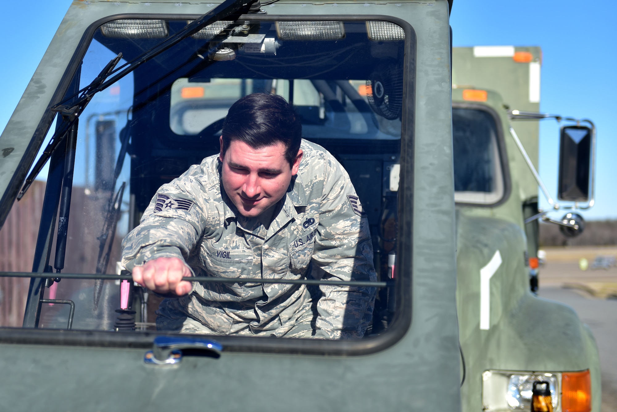 An Airman closes the door to a de-icing truck.
