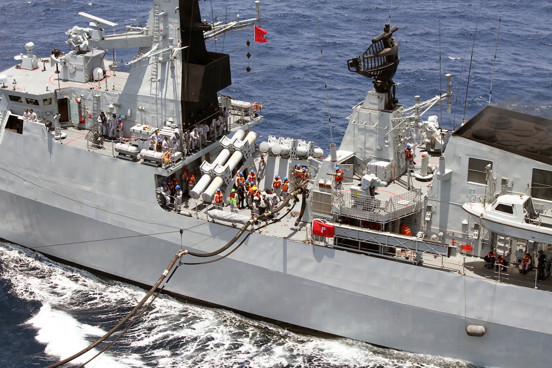 Safety observers from Military Sealift Command’s dry cargo and ammunition ship USNS Washington Chambers stand alongside Royal Malaysian Navy sailors aboard frigate RMN KD Lekiu during an underway replenishment.