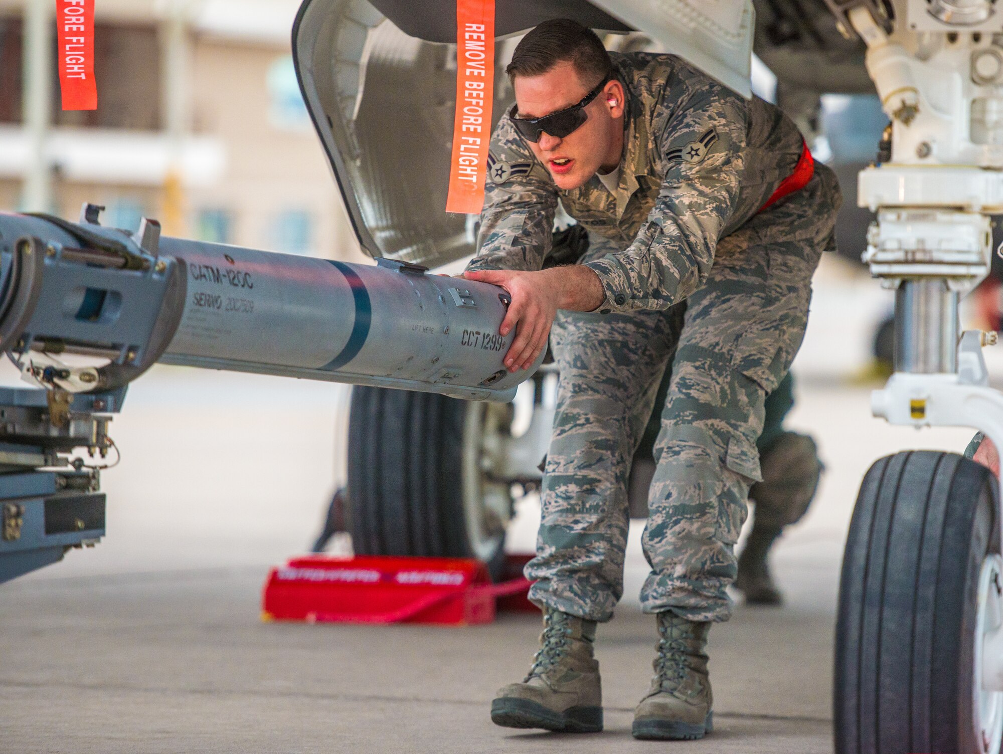 Airman 1st Class Dillin Mattos, 63rd Aircraft Maintenance Unit load crew team member, guides an inert missile tonto an F-35A Lightning II during the 56th Fighter Wing Quarterly Load Crew Competition at Luke Air Force Base, Ariz., Jan. 10, 2019.