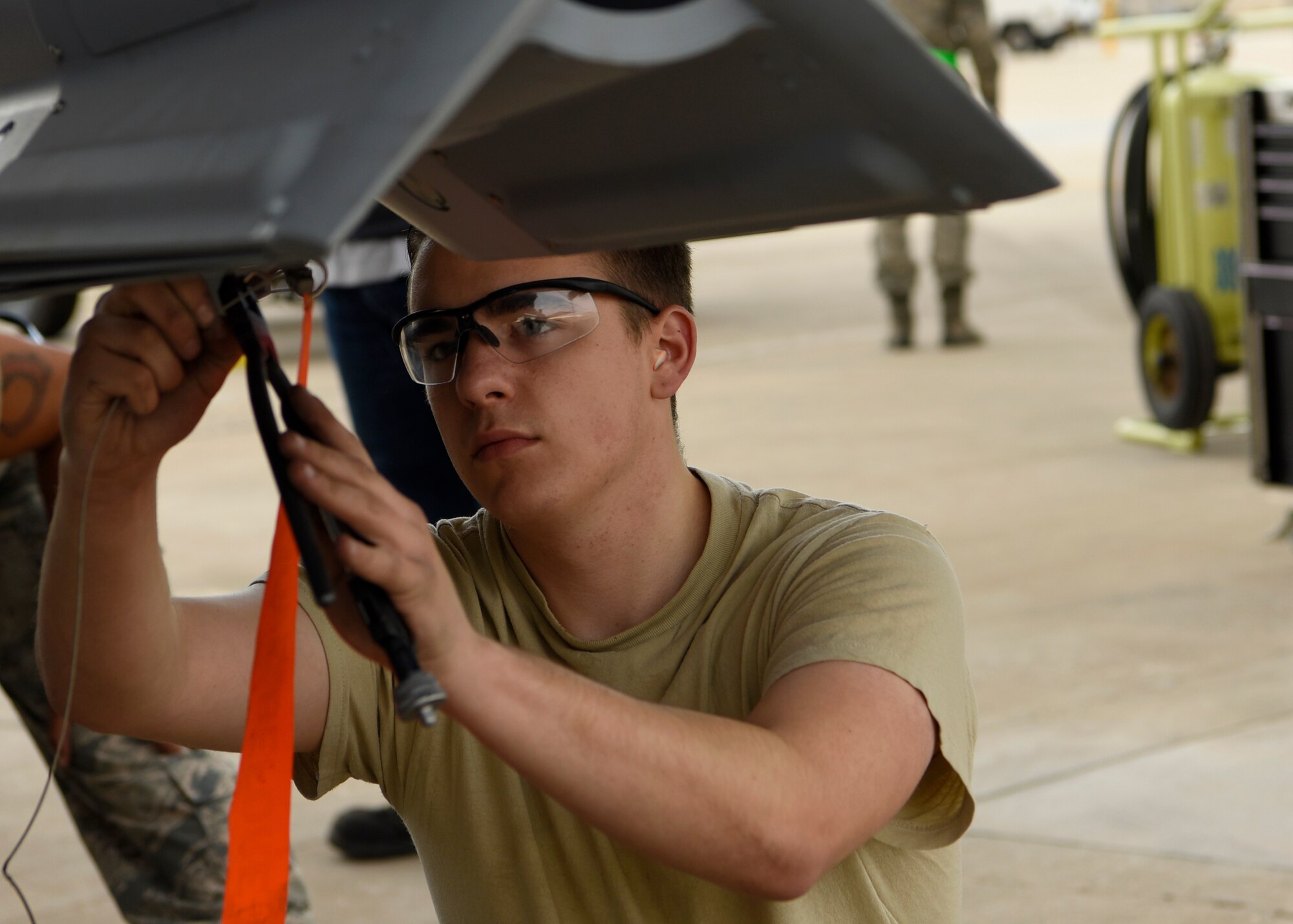 Airman 1st Class Joshua Elias, 309th Aircraft Maintenance Unit load crew team member, prepares to affix an inert bomb to an F-16 Fighting Falcon during the 56th Fighter Wing Quarterly Load Crew Competition at Luke Air Force Base, Ariz., Jan. 10, 2019.