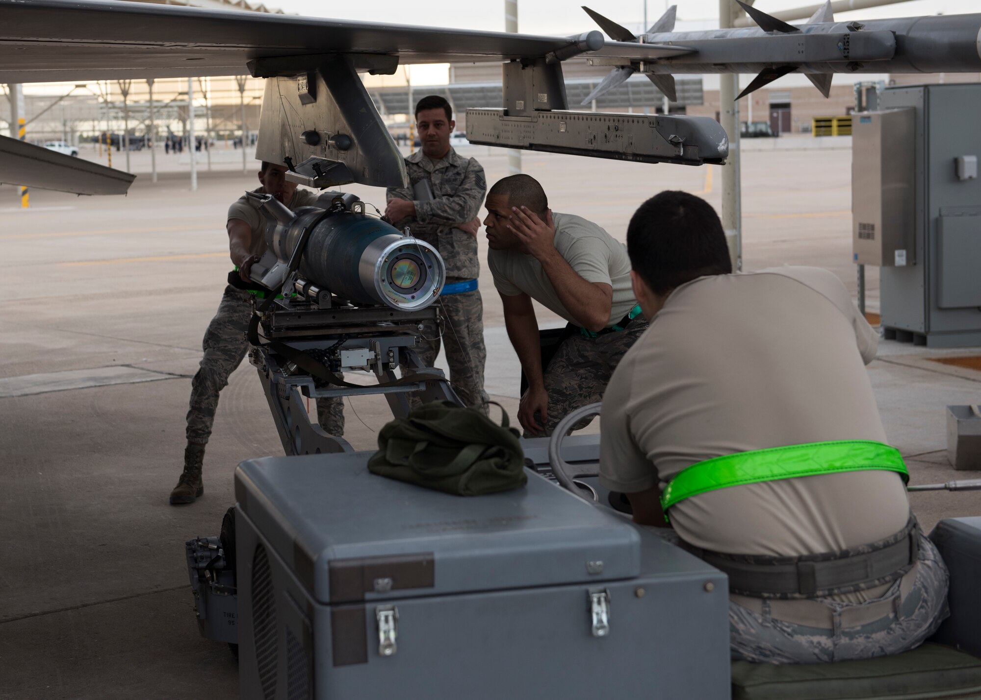 Staff Sgt. Ralphy Rosado, 310th Aircraft Maintenance Unit load crew chief, ushers an inert bomb into position for loading onto an F-16 Fighting Falcon at Luke Air Force Base Ariz., Jan. 10, 2019.