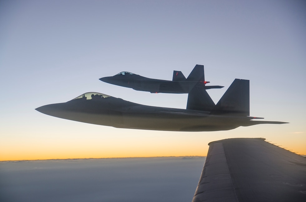 Two F-22 Raptors from the 94th Expeditionary Fighter Squadron, Al Dhafra Air Base, United Arab Emirates, fly in formation after refueling from a 908th Expeditionary Air Refueling Squadron KC-10 Extender over Southwest Asia, Sept. 12, 2018.