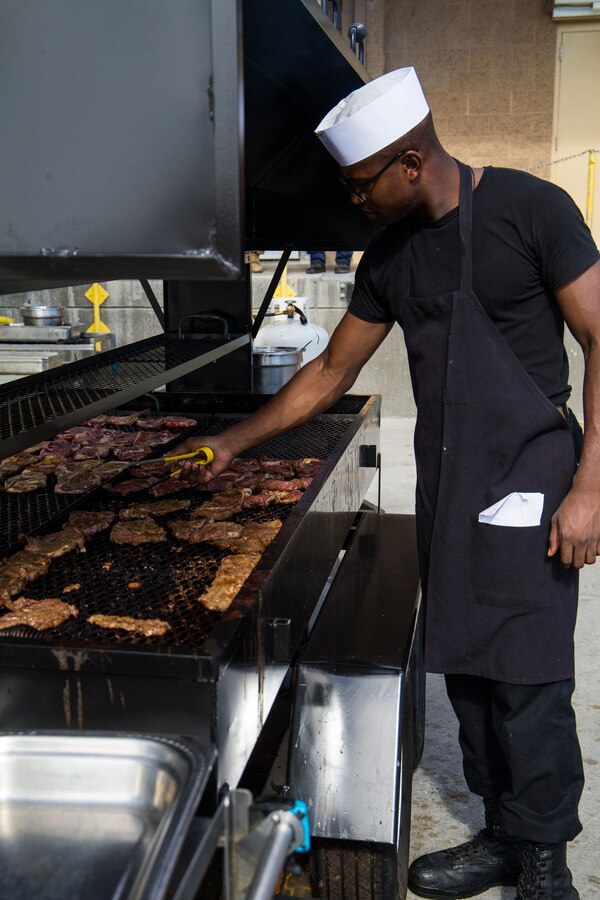 Pfc. Malik Kennedy, a food service specialist with Alpha Company, Headquarters Battalion, grills steaks in preparation of the U.S. Navy’s 243rd birthday, at Phelps Chow Hall, aboard Marine Corps Air Ground Combat Center, Twentynine Palms, Calif., Oct. 11, 2018. Founded on Oct. 13, 1775, the Continental Navy was created by Congress to defend and protect American coastal communities and colonies from British attacks, and to disrupt British communications.  (U.S. Marine Corps photo by Lance Cpl. Rachel K. Young)