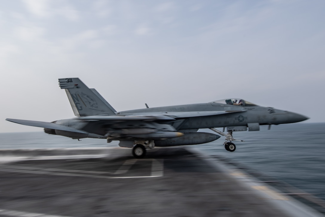 An F/A-18E Super Hornet launches from a flight deck.