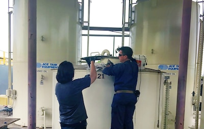 Naval Facilities Engineering Command Hawaii employees conduct sampling of fuel oil reclaimed.