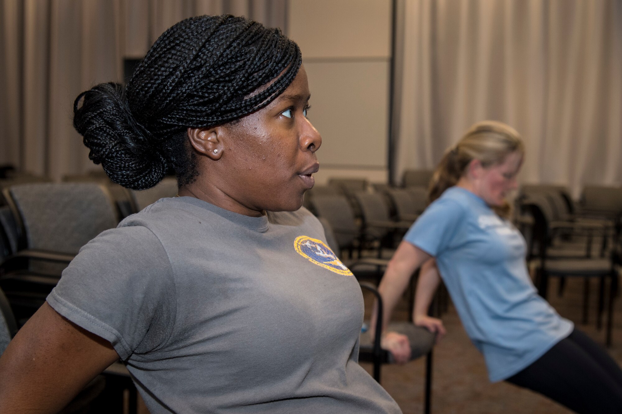 Senior Airman April Ratcliff, 514th Force Support Squadron personnel specialist, and Captain Deborah K. Hautanen, 514th FSS operations officer, both with the 514th Air Mobility Wing, Joint Base McGuire-Dix-Lakehurst, N.J., perform chair dips during a High Intensity Interval Training class, January 12, 2019. The HIIT class is offered in the auditorium of the 514th FSS building on alternating Saturdays of the Unit Training Assembly weekend. (U.S. Air Force photo by Senior Airman Ruben Rios)