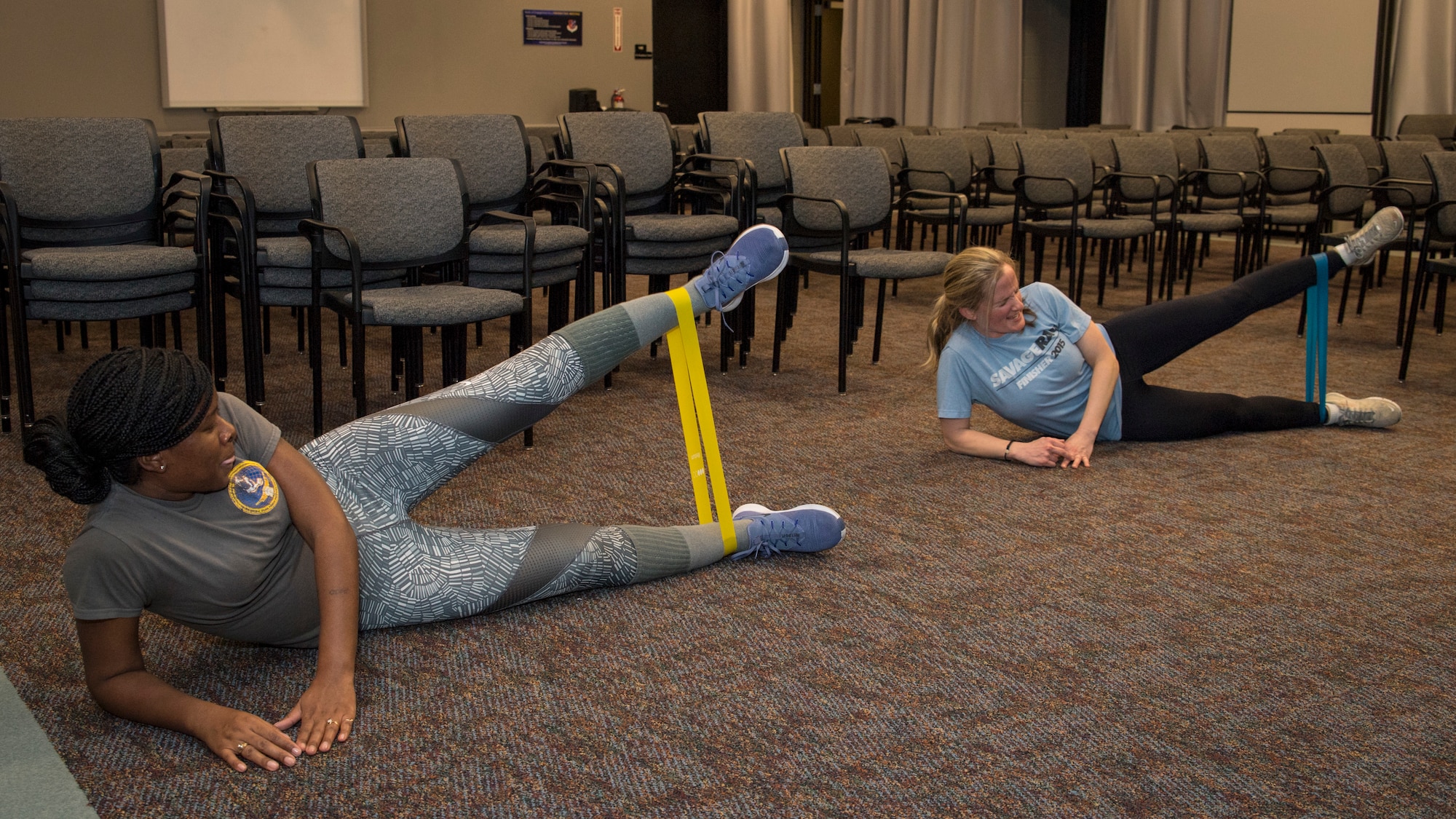 Senior Airman April Ratcliff, 514th Force Support Squadron personnel specialist, and Captain Deborah K. Hautanen, 514th FSS operations officer, both with the 514th Air Mobility Wing, Joint Base McGuire-Dix-Lakehurst, N.J., perform side leg raises during a High Intensity Interval Training class, January 12, 2019. The HIIT class is offered in the auditorium of the 514th FSS building on alternating Saturdays of the Unit Training Assembly weekend. (U.S. Air Force photo by Senior Airman Ruben Rios)