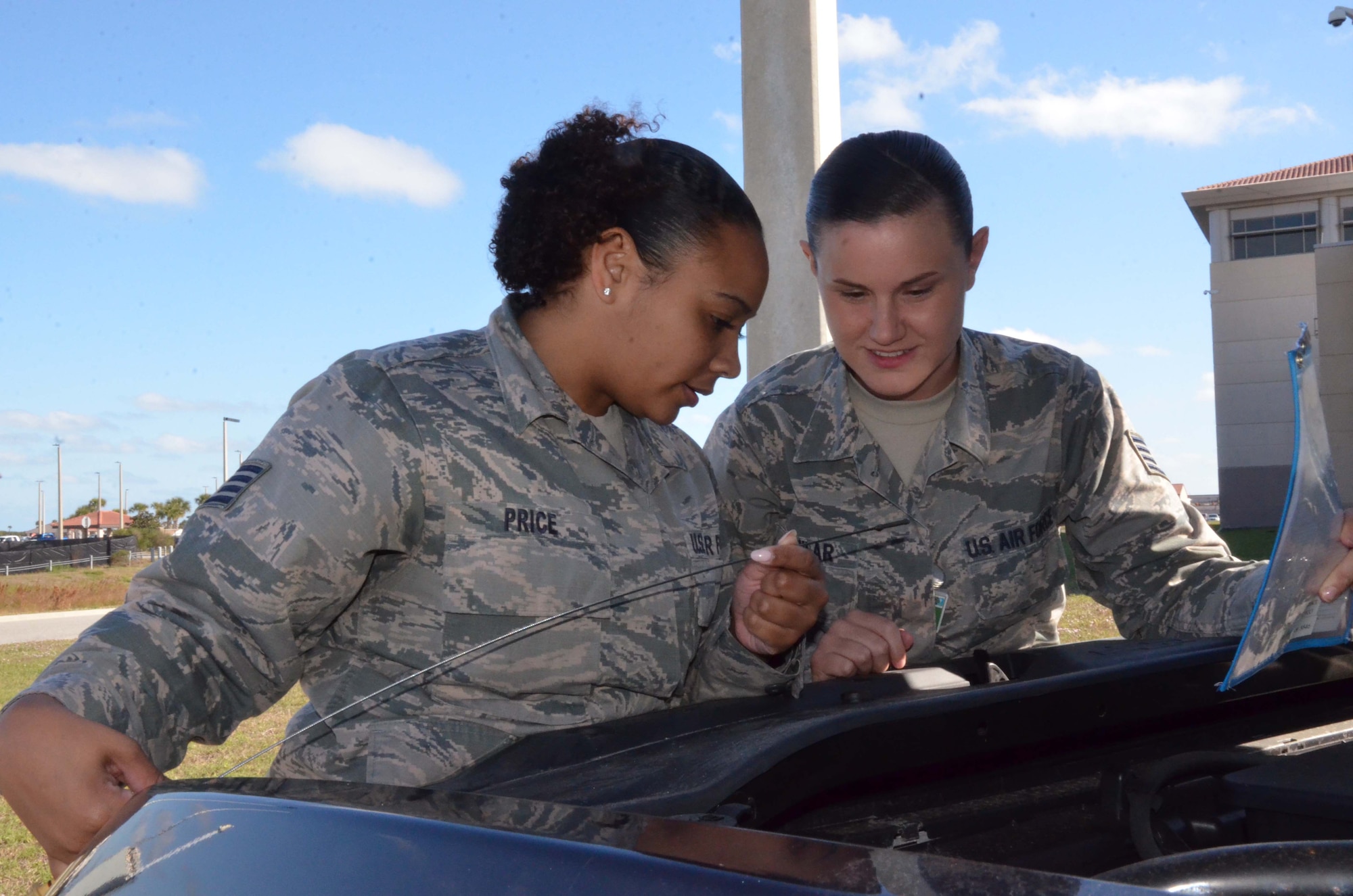 Staff Sgt. Briana Price, noncommissioned officer in charge of transportation, and Staff Sgt. Ashley Aguilar, transportation support liaison, inspect an oil dipstick from a vehicle assigned to the 709th Support Squadron, Air Force Technical Applications Center, Patrick AFB, Fla.  The two NCOs assisted with recent streamlining operations in the squadron's transportation section.