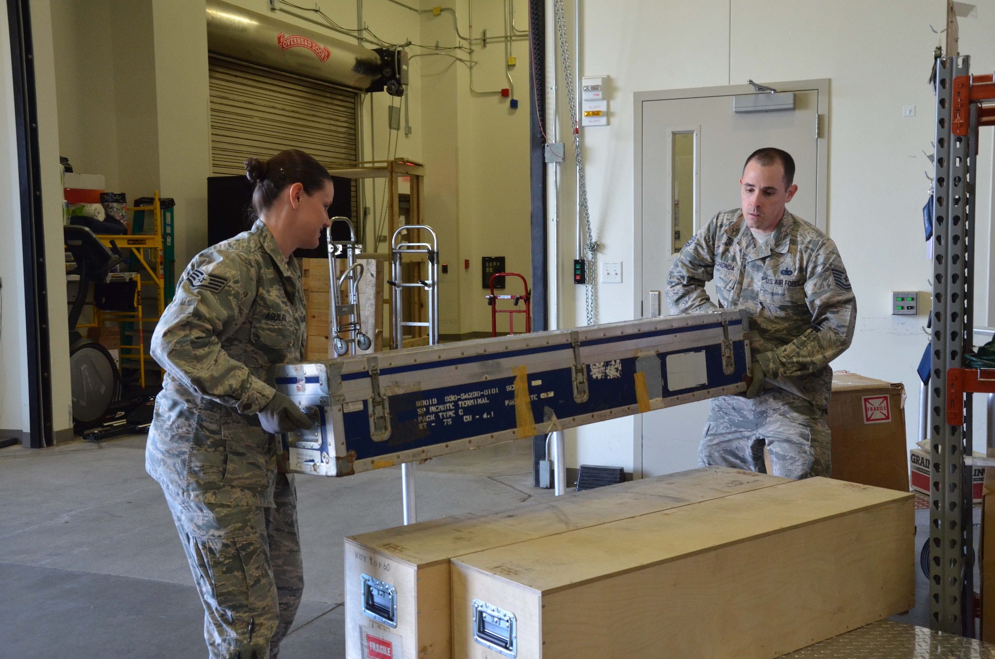 Staff Sgt. Ashley Aguilar and Tech. Sgt. Mark Melchionda, both members of the 709th Support Squadron at the Air Force Technical Applications Center, Patrick AFB, Fla., carefully relocate a shipment of seismic equipment the center uses for its global nuclear treaty monitoring mission.