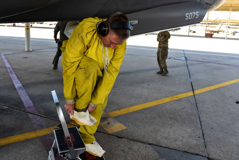 Tech. Sgt. Lance Dooley, a crew chief in the 466th Aircraft Maintenance Unit, prepares to crawl inside the intake of an F-35 Lightning II to perform a post-flight inspection
