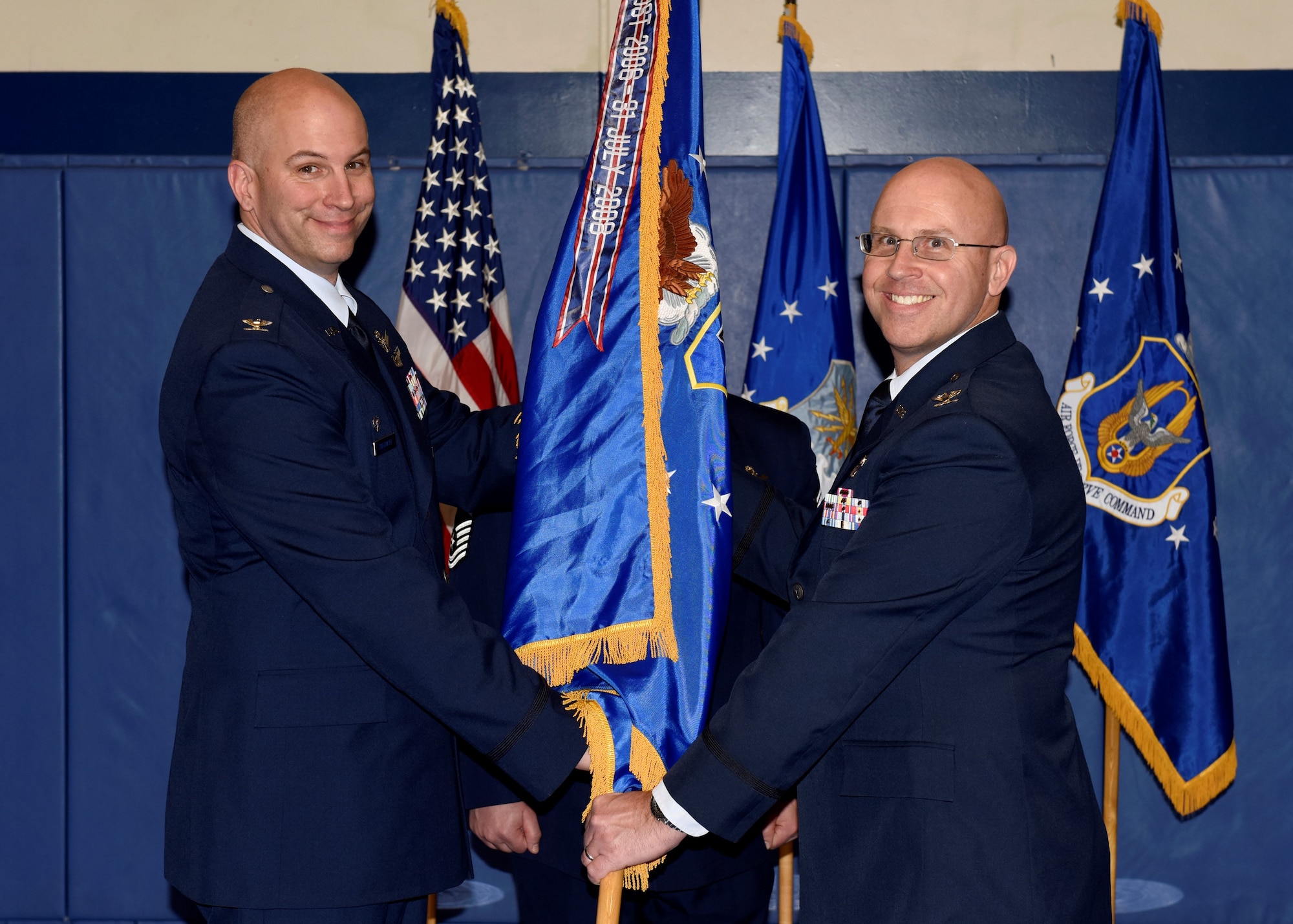 Col. Dean Sniegowski, 310th Space Wing commander, passes the 310th Operations Group guidon to Col. Leland Leonard, incoming 310th OG commander, during a change of command ceremony Saturday, Jan. 5th, 2019.