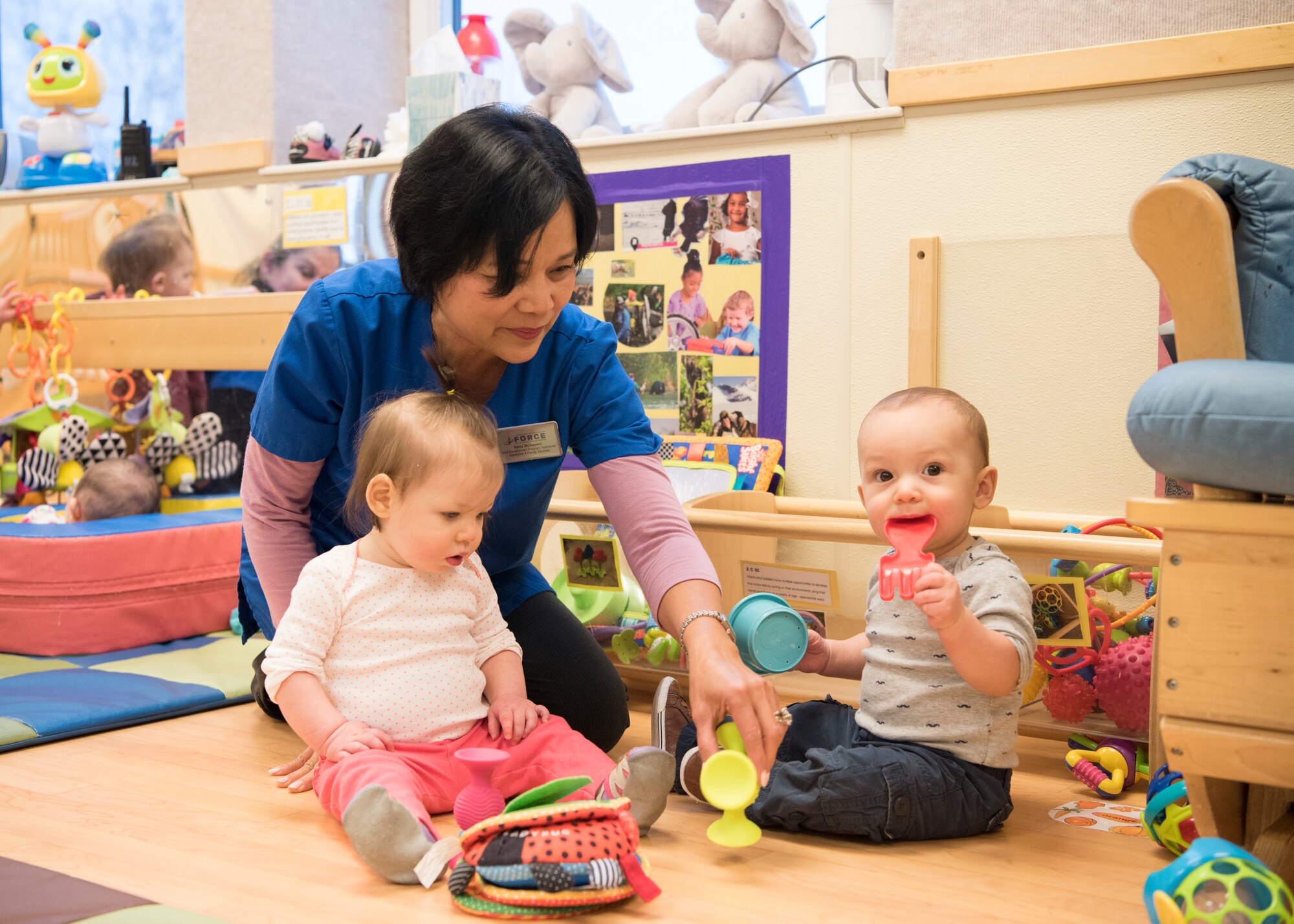 Nelia McKeown, a Sitka Child Development Center child and youth program assistant, gives children toys to play with during playtime at Joint Base Elmendorf-Richardson, Alaska, Dec. 14, 2018. All five JBER CDC centers are accredited by the National Association for the Education of Young Children and provide childcare for ages 6 weeks to 5 years. Due to a shortage in workers JBER is hiring child development center workers – including teachers, cooks and food service workers.
