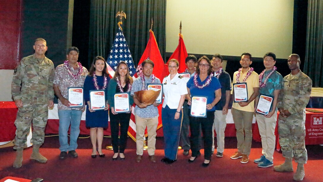 Project Manager Lance Sewake (center) and the FY16 PTA Repair Cespool Project Delivery Team accept the 2018 PDT of the Year Koa Bowl Award from Honolulu District Commander Lt. Col. Kathyrn Sanborn (center right)and Pacific Ocean Division Commander. Brig. Gen. Thomas Tickner (left) during the District's Annual Awards Townhall held Jan. 9, 2019.