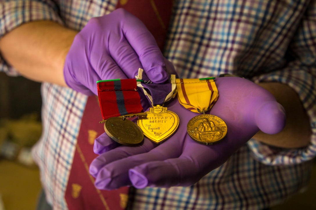 Owen Conner, uniforms and heraldry curator with the National Museum of the Marine Corps, inspects medal collection belonging to U.S. Marine Corps Sgt. Russell Rose at warehouse 2288, Marine Corps Base Camp Pendleton, Calif., Jan. 10.