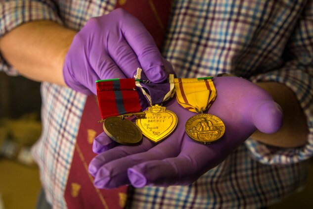 Owen Conner, uniforms and heraldry curator with the National Museum of the Marine Corps, inspects medal collection belonging to U.S. Marine Corps Sgt. Russell Rose at warehouse 2288, Marine Corps Base Camp Pendleton, Calif., Jan. 10.