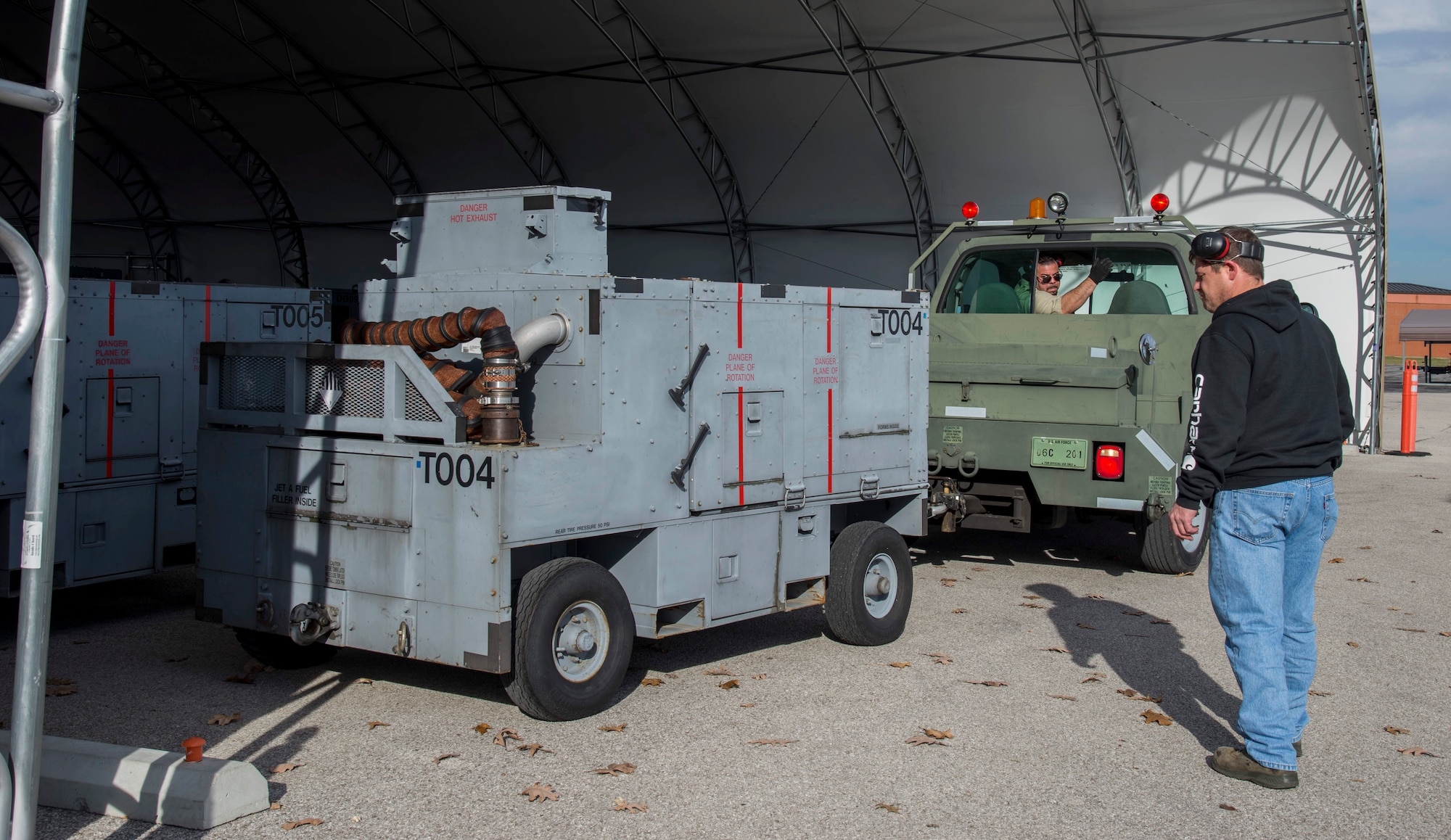 Ernesto Realsantana, 375th Operations Support Squadron aerospace ground equipment mechanic, backs up an air start cart while Jeff Dalton, 375th OSS AGE mechanic, spots him at Scott Air Force Base, Illinois, Dec. 12, 2018. Air start carts are needed to start certain aircraft engines allowing them to take off.