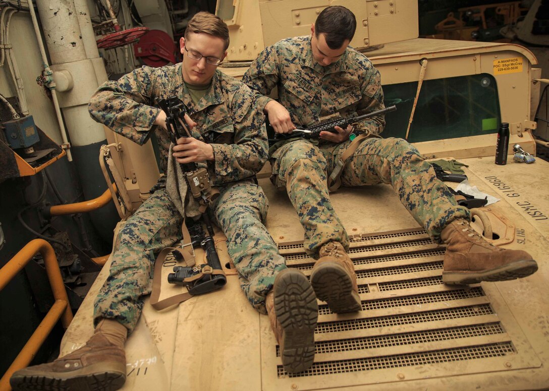 Infantry Marines with the 22nd Marine Expeditionary Unit perform routine maintenance on their M4A1 service rifles while atop a Humvee in the well deck of the USS Kearsarge (LHD 3), Jan. 7, 2019. The Marines are with Charlie Company, 1st Battalion, 2nd Marine Regiment and aboard the Kearsarge as it transports the 22nd MEU on deployment. (U.S. Marine Corps photo by Lance Cpl. Tawanya Norwood)