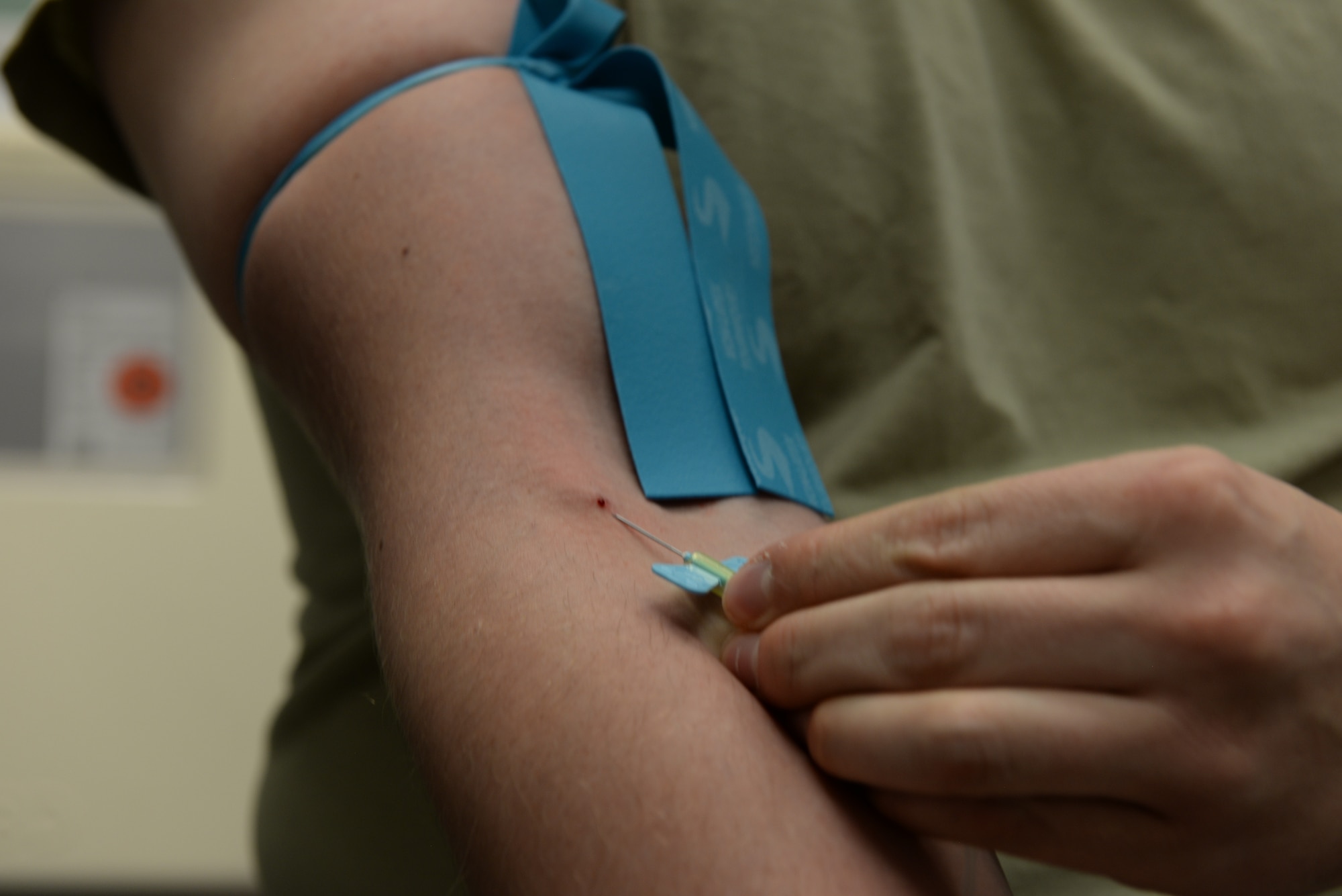 Staff Sgt. Johnathon Barton, the 28th Medical Support Squadron noncommissioned officer in charge of central operations, inserts a needle into himself to show how to properly inject one during a training exercise at the 28th Medical Group laboratory at Ellsworth Air Force Base, S.D., Dec. 4, 2018. Phlebotomists-in-training can intern at the base clinic to get hands on experience for their degree. (U.S. Air Force photo by Airman 1st Class Nicolas Z. Erwin)