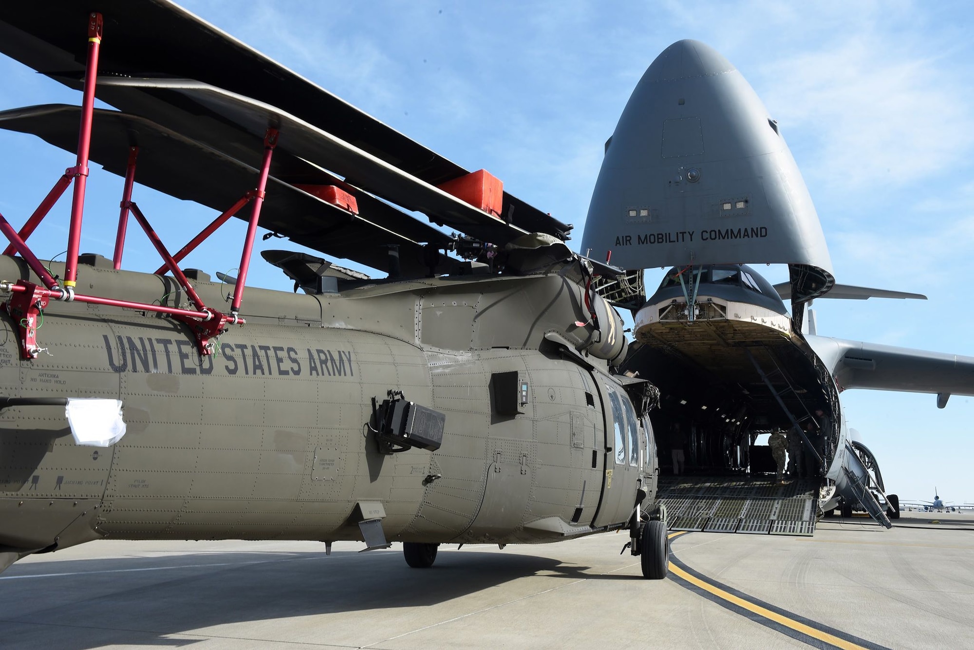 A U.S. Army UH-60 Black Hawk waits to be loaded up into a C-5M Super Galaxy as part of full-spectrum readiness training January 13 at Travis Air Force Base, Calif. The C-5M is not the normal transport for the Black Hawks, but was offered as transport to the Army in the interest of full-spectrum readiness training for Travis’ C-5M personnel. (U.S. Air Force photo by Airman 1st Class Christian Conrad)