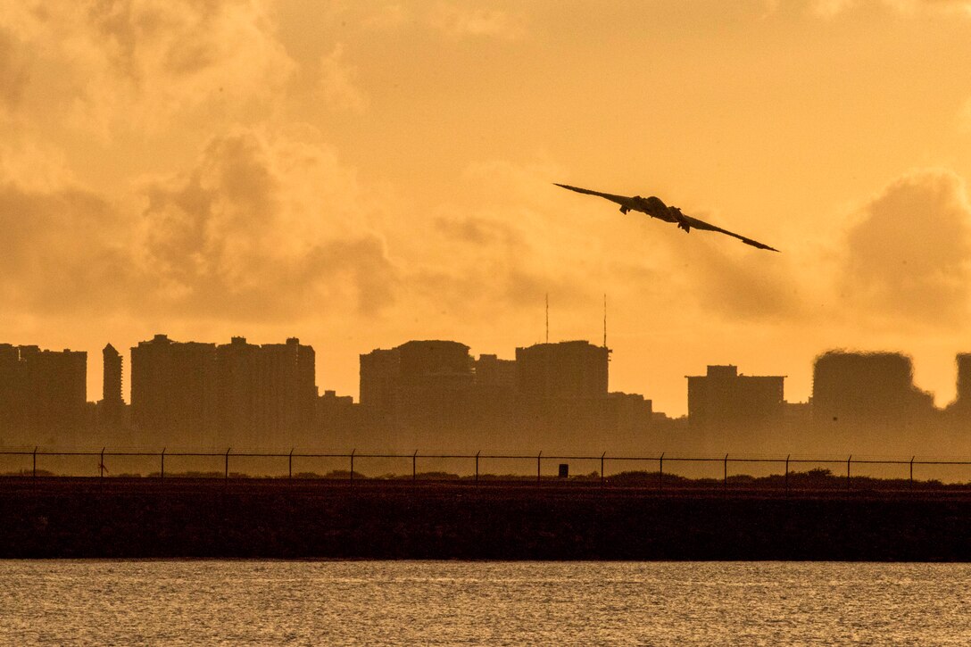 A B-2 Bomber takes off in front of the Pearl Harbor skyline.