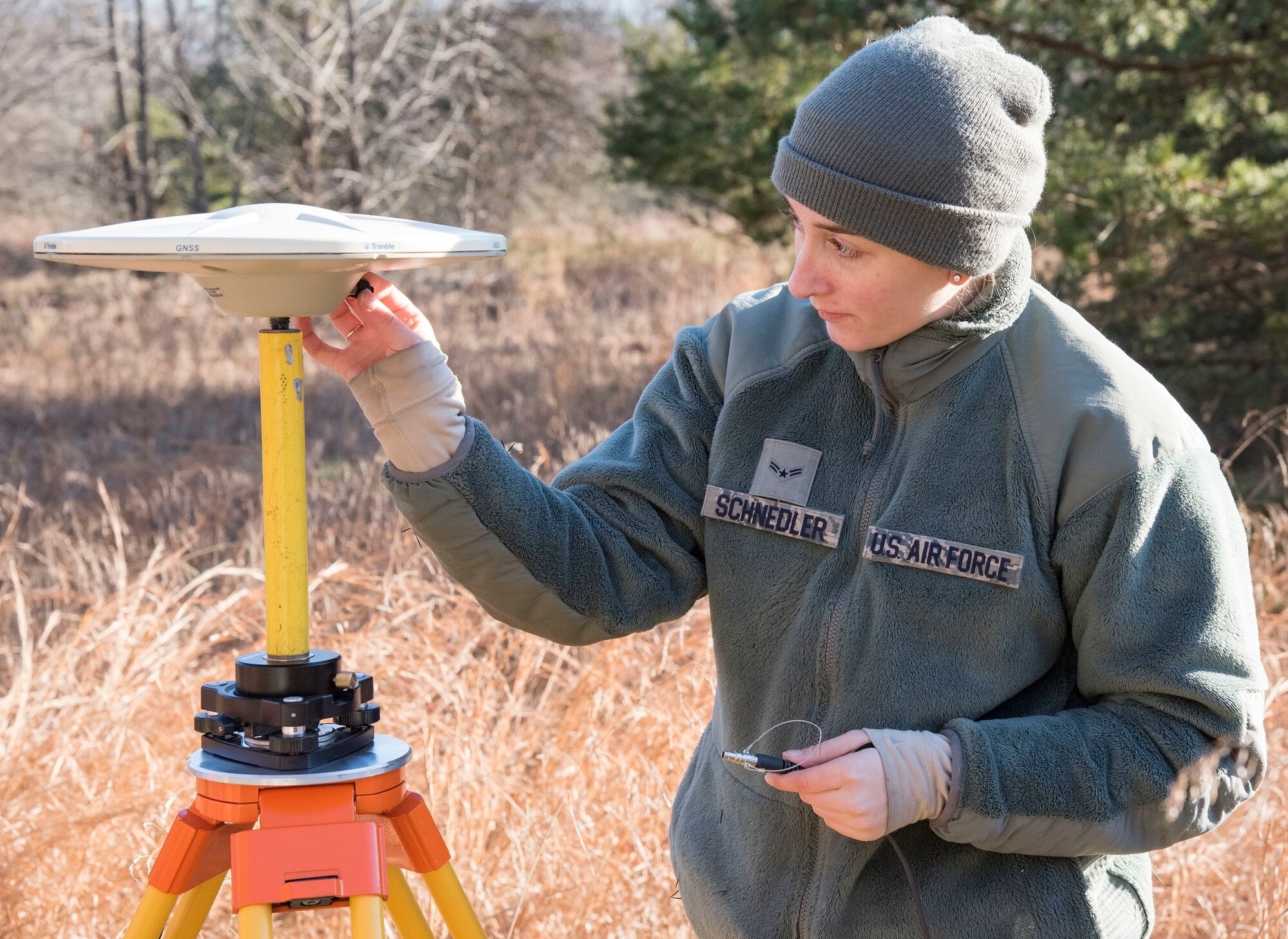 Airman 1st Class Angela Schnedler, 436th Civil Engineer Squadron engineering journeyman sets up a GPS surveying base station during an aircraft mishap survey exercise Dec. 18, 2018, near Killens Pond State Park, Kent County, Del. Schnedler ensured the base station was communicating with GPS satellites orbiting the Earth. (U.S. Air Force photo by Roland Balik)