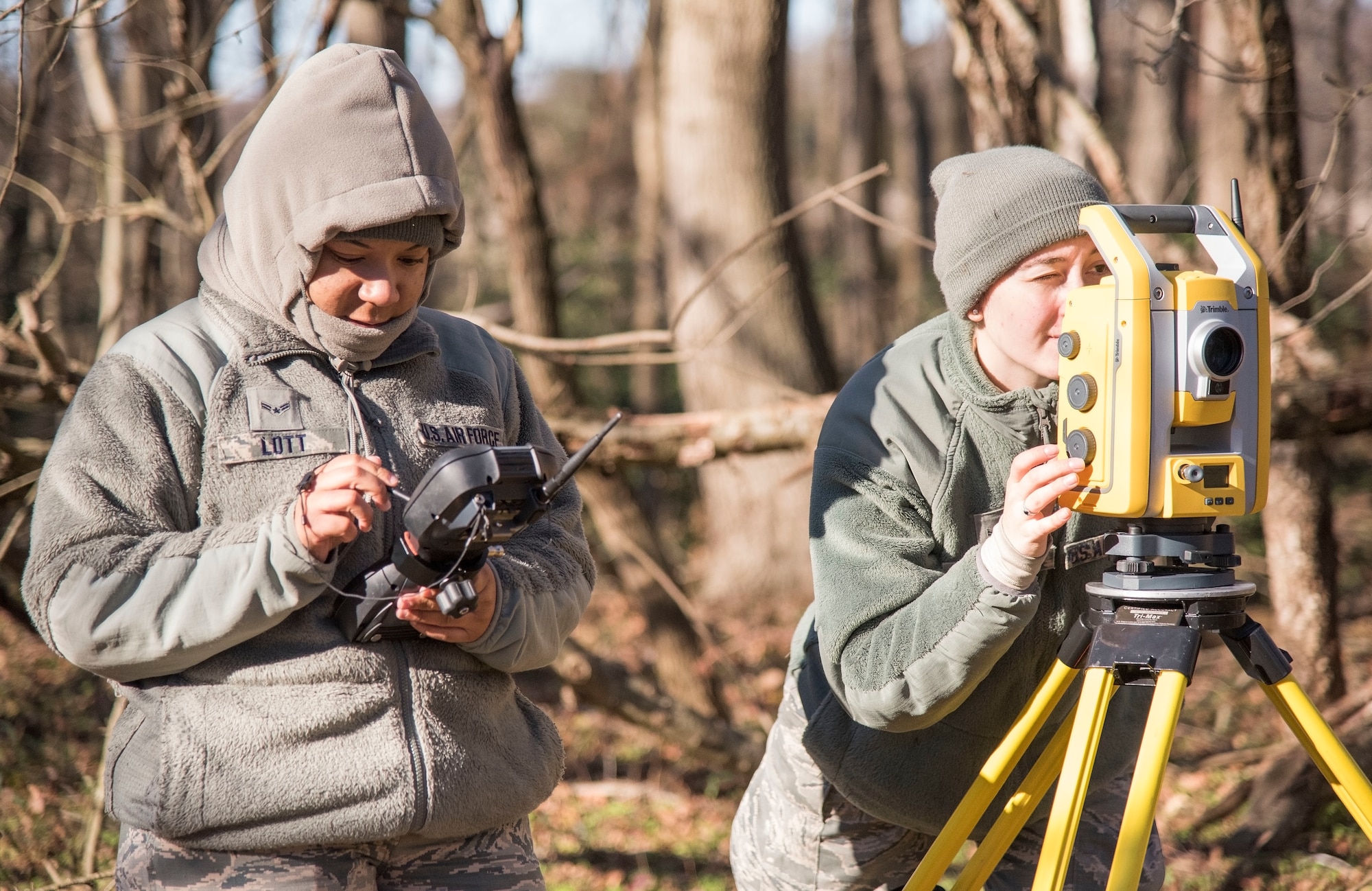 Airman 1st Class Alishia Lott and Angela Schnedler, 436th Civil Engineer Squadron engineering journeymen use surveying equipment to record debris location during an aircraft mishap survey exercise Dec. 18, 2018, near Killens Pond State Park, Kent County, Del. Lott and Schnedler documented the exact location of miscellaneous aircraft and aircrew items of a simulated T-38 Talon aircraft mishap using GPS satellites. (U.S. Air Force photo by Roland Balik)