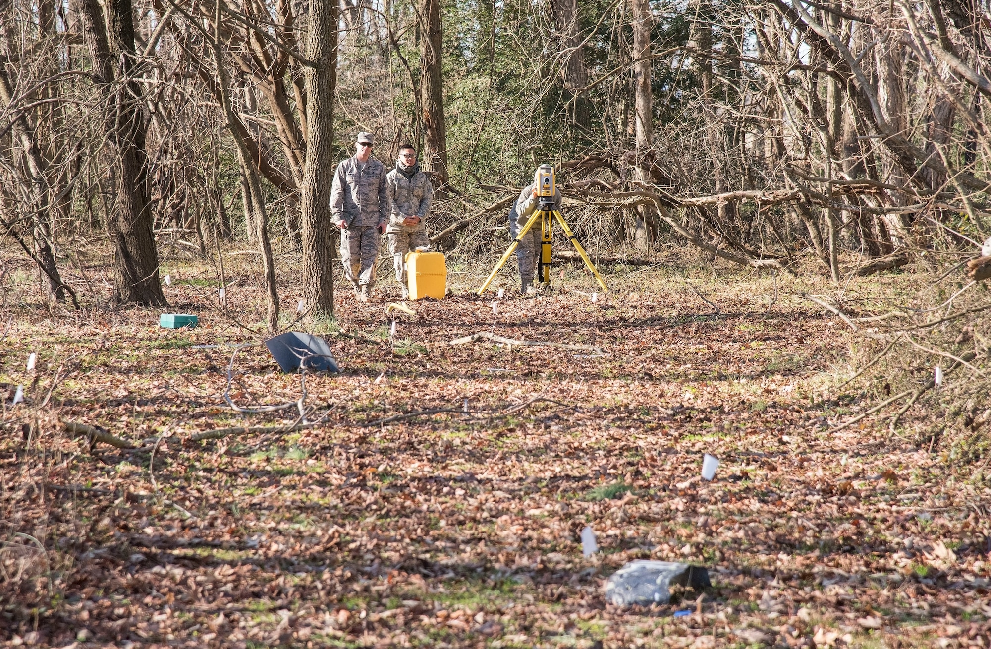 From left to right, Master Sgt. Jason McNabb, Senior Airman Edcyril Ernest Mallonga, and Airman 1st Class Alishia Lott, all from the 436th Civil Engineer Squadron engineering flight, look at a simulated debris field during an aircraft mishap survey exercise Dec. 18, 2018, near Killens Pond State Park, Kent County, Del. McNabb observed and instructed survey team members on procedures and methods used to document debris from an aircraft mishap. (U.S. Air Force photo by Roland Balik)