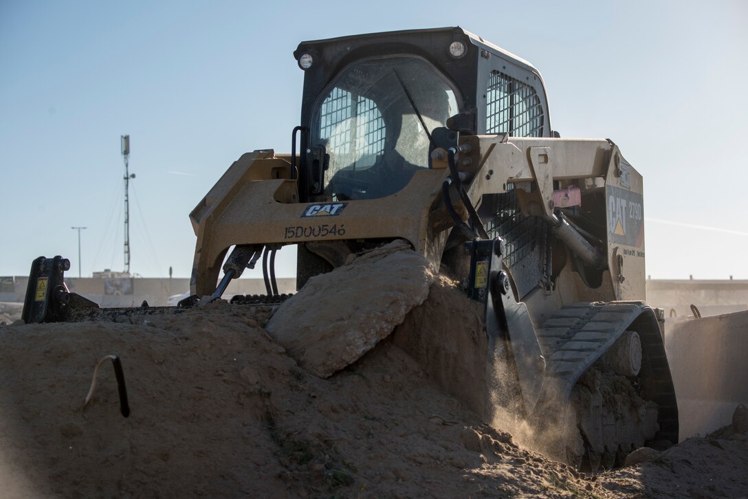 Staff Sgt. Patrick Chuba, 386th Expeditionary Civil Engineer Squadron pavement and equipment journeyman, pushes soil away from the barriers at an undisclosed location in Southwest Asia, Jan. 10, 2019. During this rotation's time here, this project was one of the largest and a top priority for leadership