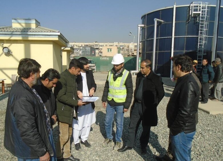 The end user for the Police Town Water Tank replacement look over the Operation and Maintenance Manual they received with the turnover of the project.