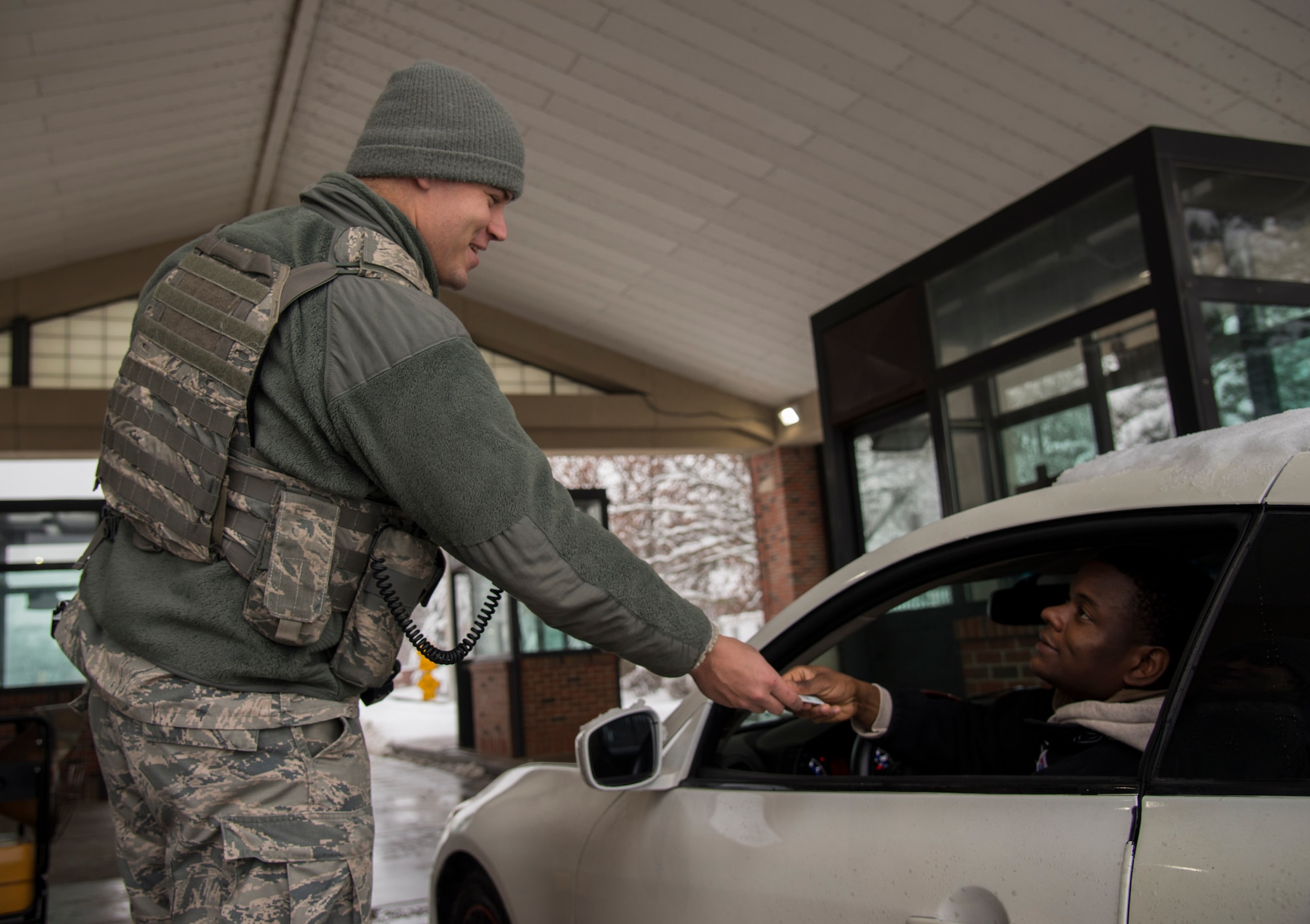 Senior Airman Jay Coil, 375th Security Forces Squadron patrolman, checks an ID card at the Belleville gate Jan. 12, 2019 at Scott Air Force, Ill. Members of the 375th SFS are mission essential personnel and still must ensure the safety and security of the base even during a snow storm.