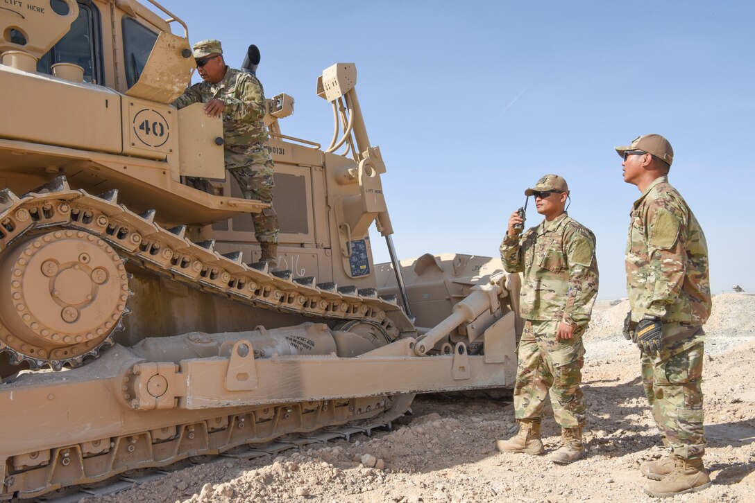 624th Civil Engineer Squadron Reservists Tech. Sgt. Adonicio Balignasay, 380th Expeditionary Civil Engineer Squadron heavy equipment operator, performs an initial inspection of a bull dozer as Tech. Sgt. Rene Macapagal, 380th ECES heavy equipment operator, and Tech. Sgt. Michael Pascual, 380th ECES heavy equipment operator, receives guidance, Jan. 9, 2019 at Al Dhafra Air Base, United Arab Emirates.
