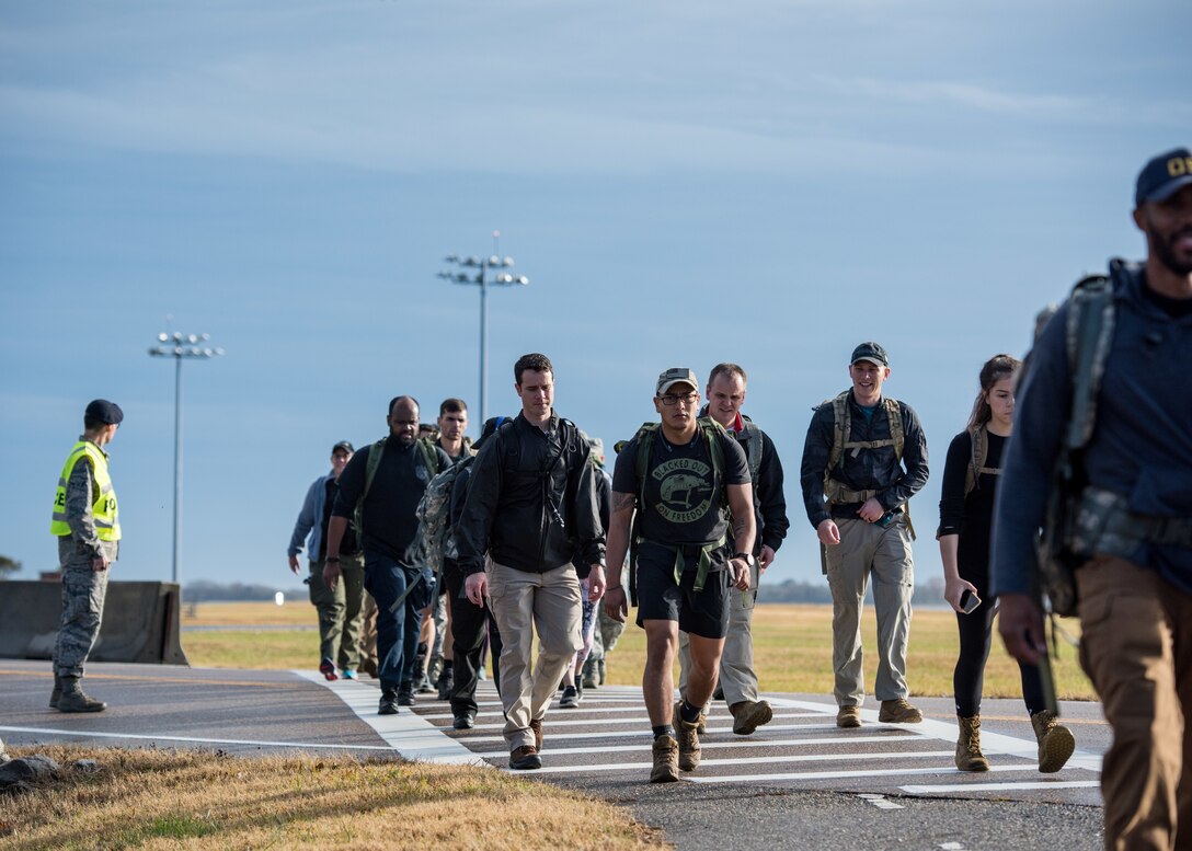 Members of the 633rd Security Forces Squadron, Air Force Office of Special Investigation and Naval Criminal Investigative Services conduct a ruck march in memory of joint patrol team, Hustler 6, at Joint Base Langley-Eustis, Virginia, Dec. 21, 2018.
