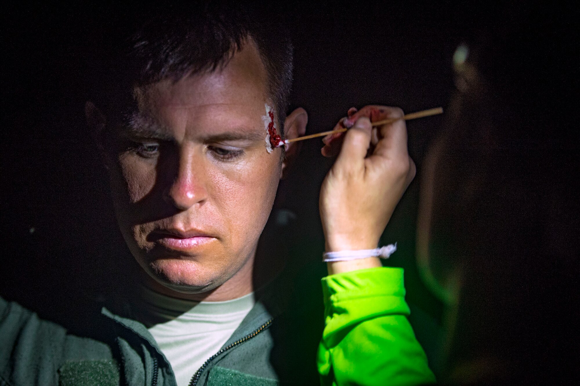 An independent duty medical technician from the 38th Rescue Squadron (RQS) paints simulated wounds onto Tech. Sgt. Levi Wood, 347th Operations Support Squadron NCO in charge of survival evasion resistance and escape (SERE) training, during a personnel recovery scenario as part of pre-deployment ‘spin-up’ training, Dec. 15, 2018, at Avon Park Air Force Range, Fla. During this pre-deployment ‘spin-up’ training, Moody’s 347th Rescue Group tested and maximized their combat search and rescue (CSAR) and personnel recovery capabilities. Under normal circumstances, the HH-60G Pave Hawk helicopter crews and maintainers deploy from Moody and integrate with Guardian Angel teams from different bases. This time, Moody’s 38th RQS and 41st RQS’s will deploy together and utilized this exercise to improve their mission readiness and cohesion before their departure. (U.S. Air Force photo by Senior Airman Greg Nash)