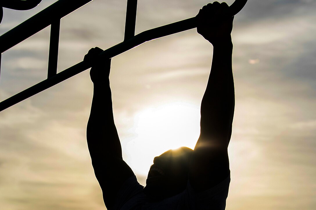 An airman performs a pullup.