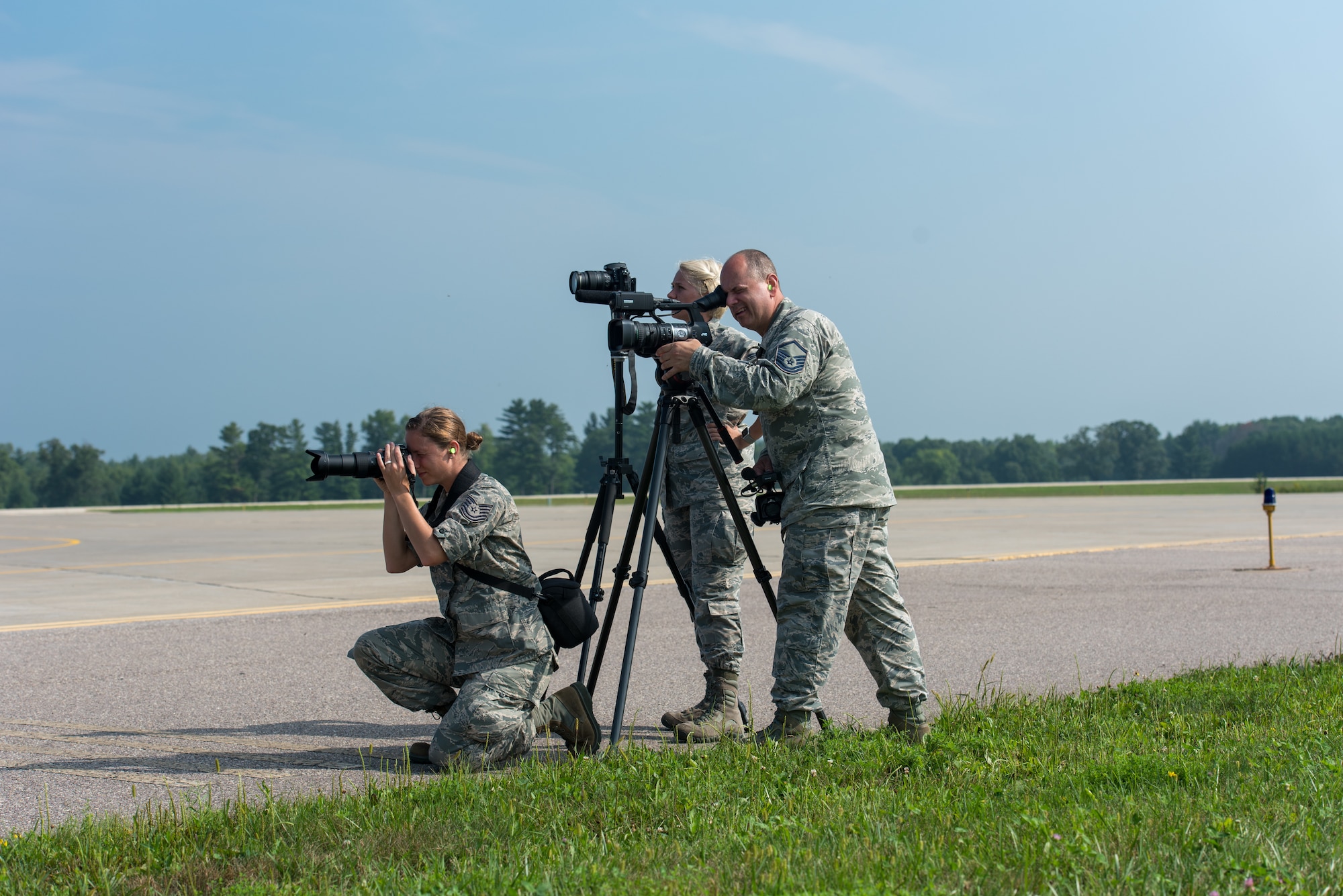 Tech. Sgt. Mary Greenwood, Airman 1st Class Madison Knabe, and Master Sgt. Paul Gorman, all public affairs Airmen with the 115th Fighter Wing, Truax Field, Wis., take photos of aircraft at Volk Field Air National Guard Base during Exercise Northern Lightning 18-2, Aug. 17, 2018. Volk field provides a year-round integrated training environment, which includes airspace, facilities, and equipment, for units to enhance their combat capabilities and readiness.(U.S. Air National Guard photo by Airman 1st Class Cameron Lewis)