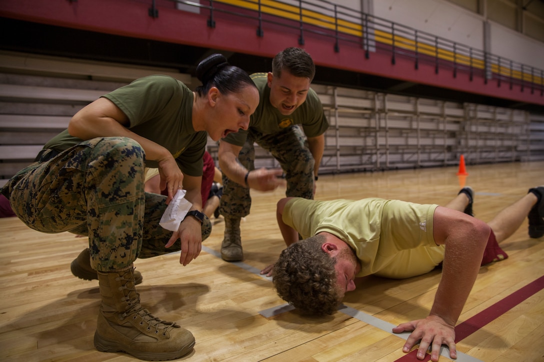 Gunnery Sgt. Kassandra Blade (left), the logistics systems coordinations chief with Headquarters Battalion, Marine Forces Reserve, and Sgt. Brandon Amarahale (center), a personnel clerk with Installation Personnel Administration Center, HQBN, MARFORRES, encourages a member of the Loyola University New Orleans baseball team during a workout session at Loyola University New Orleans, Jan. 12, 2019. Blade, a former drill instructor, brought her experience to help lead a workout that was physically challenging to the participants but also focused on teamwork and leadership. The workout session was comprised of four events; incentive training, shamrock drill, Marine Corps Martial Arts Program demonstrations and casualty evacuation drills. (U.S. Marine Corps photo by Cpl. Niles Lee)