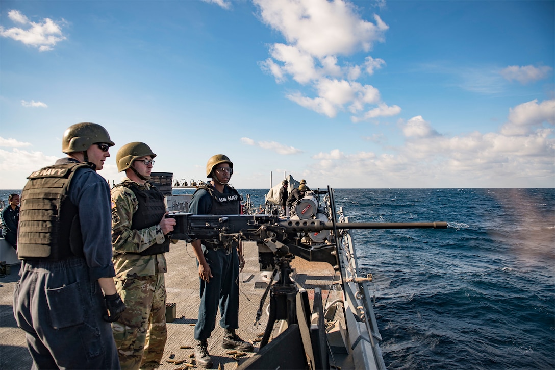 A service member fires a machine gun during an exercise.