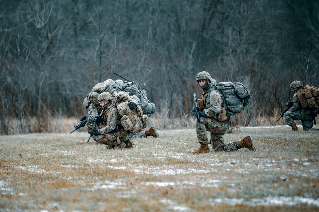 Soldiers prowl a field to provide security.