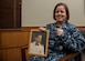 U.S. Navy Commander Kerry Beasley, poses for a photo with a portrait of her father, Maj. Wayne Brown II, while holding the two 497th Tactical Fighter Squadron rings at Joint Base Langley-Eustis, Virginia, Jan. 9, 2019.