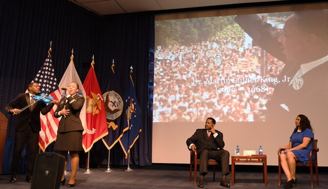 Man, woman listen to violin, solo singer on stage