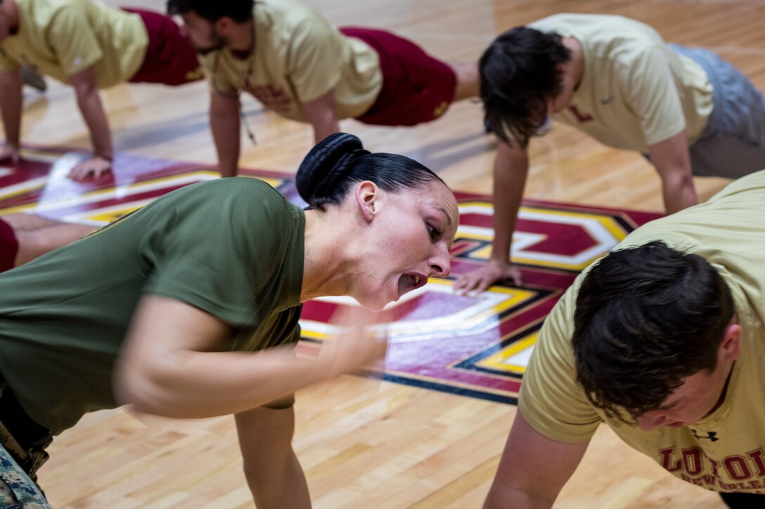Gunnery Sgt. Kassandra Blade, logistics systems coordination chief with Headquarters Battalion, Marine Forces Reserve, encourages a member of the Loyola University New Orleans baseball team, at Loyola University New Orleans, Jan. 12, 2019. Master Sgt. Bryan Smith, assistant Marine officer instructor for Tulane University and Marines with MARFORRES led a workout session that was physically and mentally challenging. The workout session was comprised of four events; incentive training, shamrock drill, Marine Corps Martial Arts Program demonstrations and casualty evacuation drills. (U.S. Marine Corps photo by Sgt. Andy O. Martinez)
