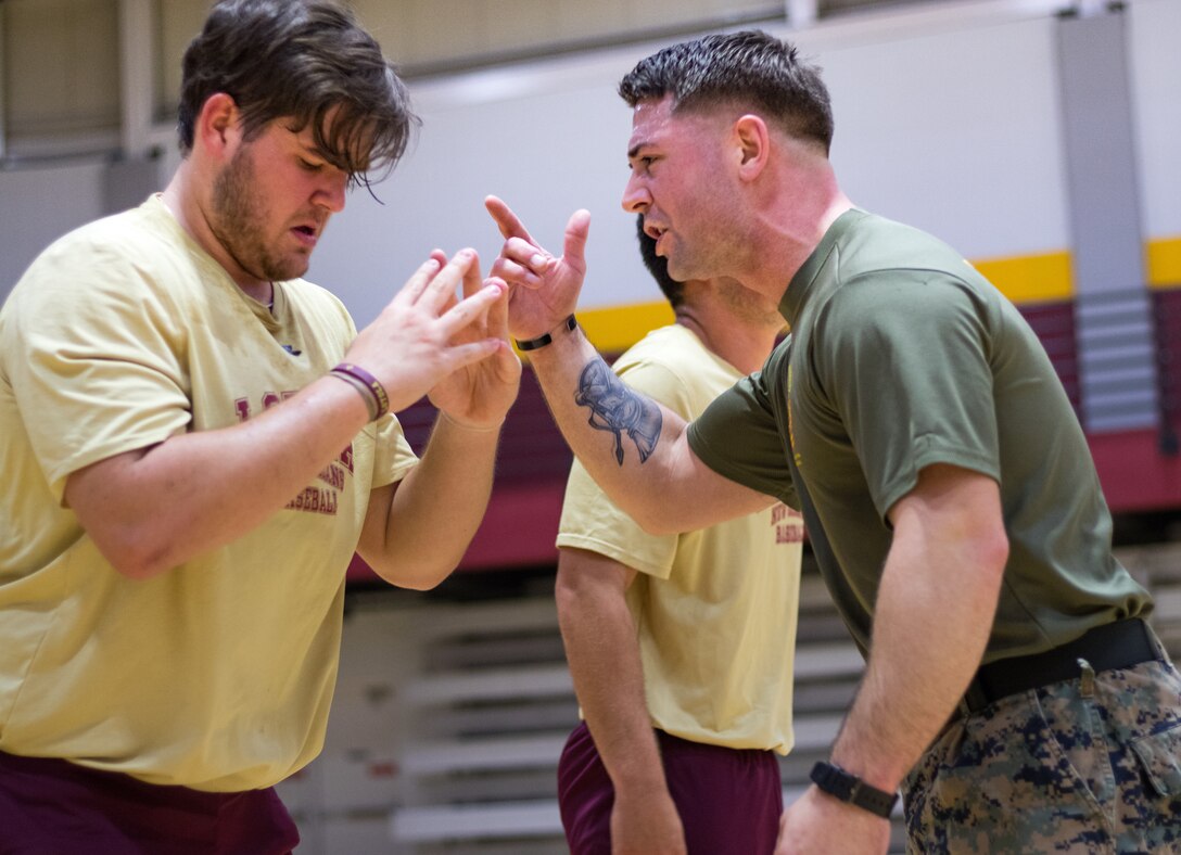 Sgt. Brandon Amarahale, personnel clerk with Installation Personnel Administration Center, Headquarters Battalion, Marine Forces Reserve, motivates a member of the Loyola University New Orleans baseball team, at Loyola University New Orleans, Jan. 12, 2019. Master Sgt. Bryan Smith, assistant Marine officer instructor for Tulane University and Marines with Marine Forces Reserve led a workout session that was physically and mentally challenging. The workout session was comprised of four events; incentive training, shamrock drill, Marine Corps Martial Arts Program demonstrations and casualty evacuation drills. (U.S. Marine Corps photo by Sgt. Andy O. Martinez)