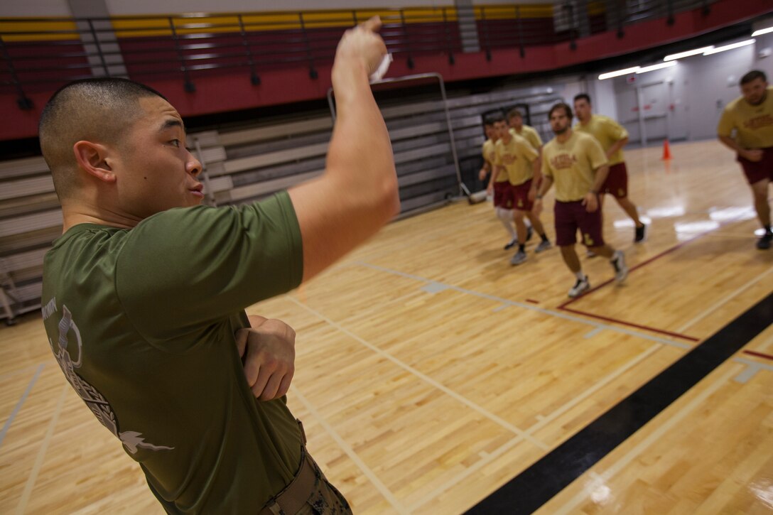 Staff Sgt. Anthony Kim, the platoon sergeant with the Marine Forces Reserve Band, directs members of the Loyola University New Orleans baseball team in a workout, at Loyola University New Orleans, Jan. 12, 2019. Kim, a former drill instructor, brought his experience to help lead a workout that was physically challenging to the participants but also focused on teamwork and leadership. The workout session was comprised of four events; incentive training, shamrock drill, Marine Corps Martial Arts Program demonstrations and casualty evacuation drills. (U.S. Marine Corps photo by Cpl. Niles Lee)