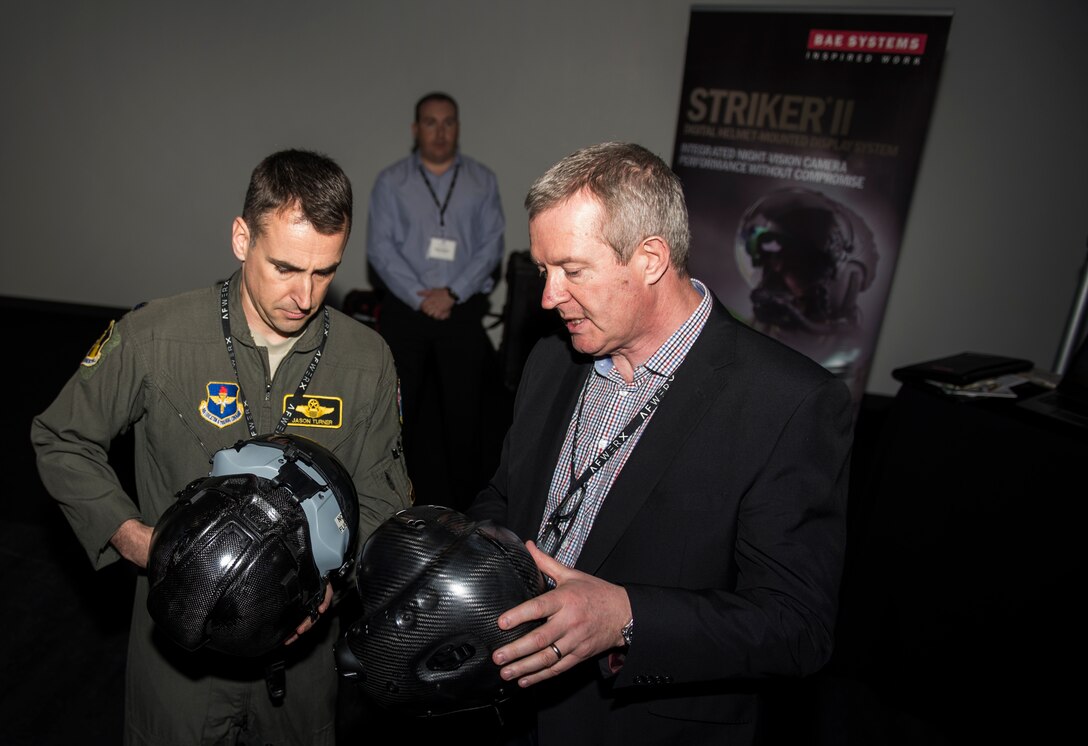 An Airman and an attendee of the AFWERX Helmet Challenge discuss new helmets at the Enclave Las Vegas, Nev., November 14, 2018. The final goal of the challenge is to enhance aircrew performance, aircrew safety and aircrew satisfaction. (U.S. Air Force photo by Airman 1st Class Bryan T. Guthrie)