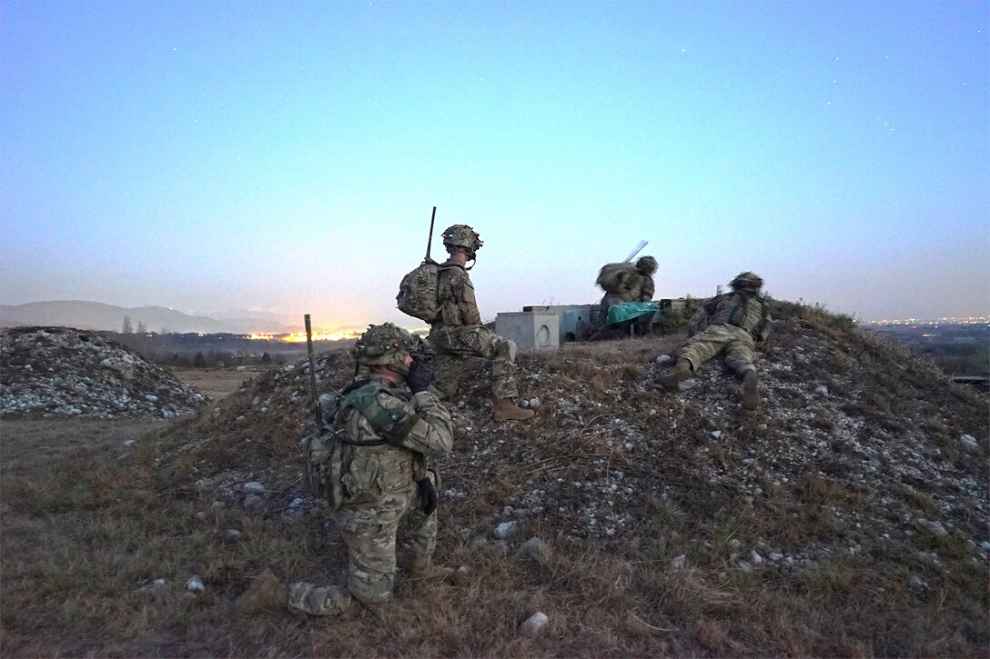 Service members crouch during a training exercise.